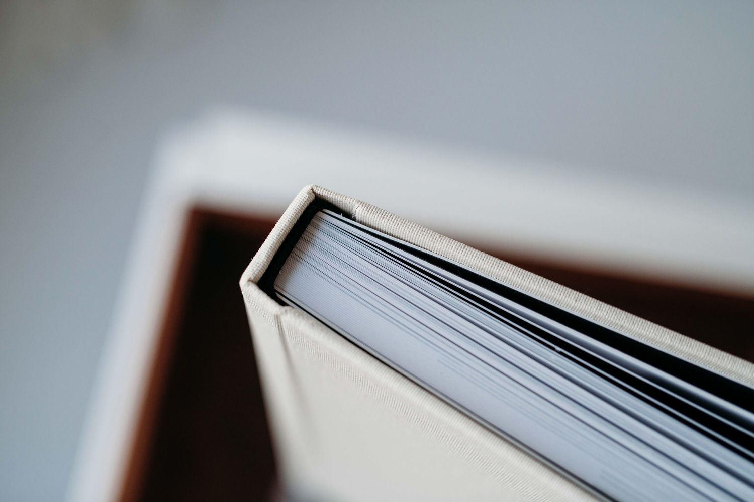 A close-up view of book pages fanned out showing white paper texture and shadows.