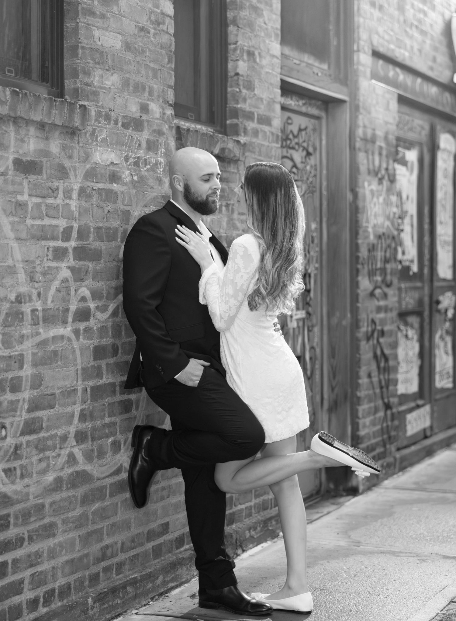 A romantic black and white photo sequence showing a couple in formal attire embracing against a brick wall.