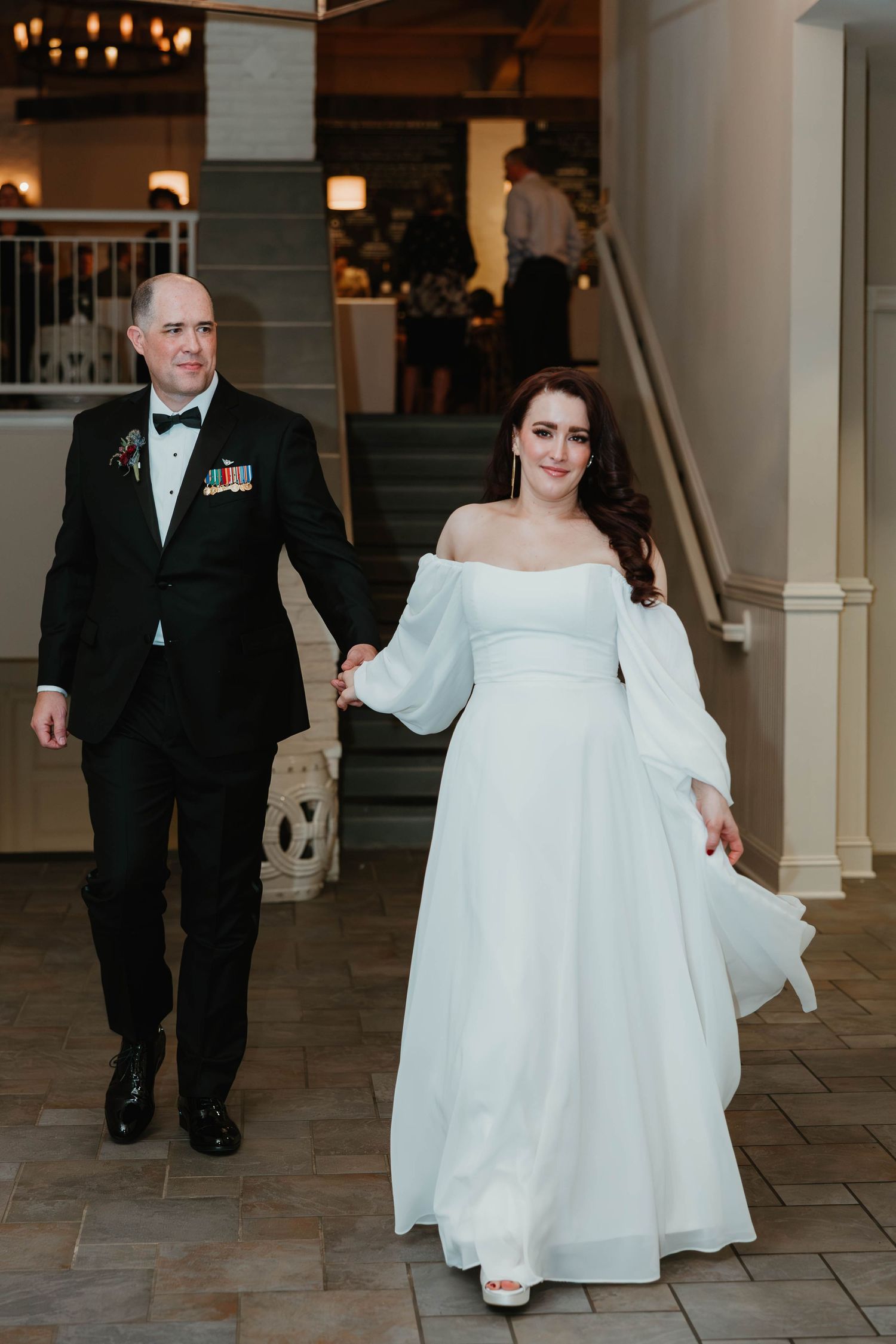 A wedding couple walks down a tiled hallway with warm lighting in a sequence of candid moments.