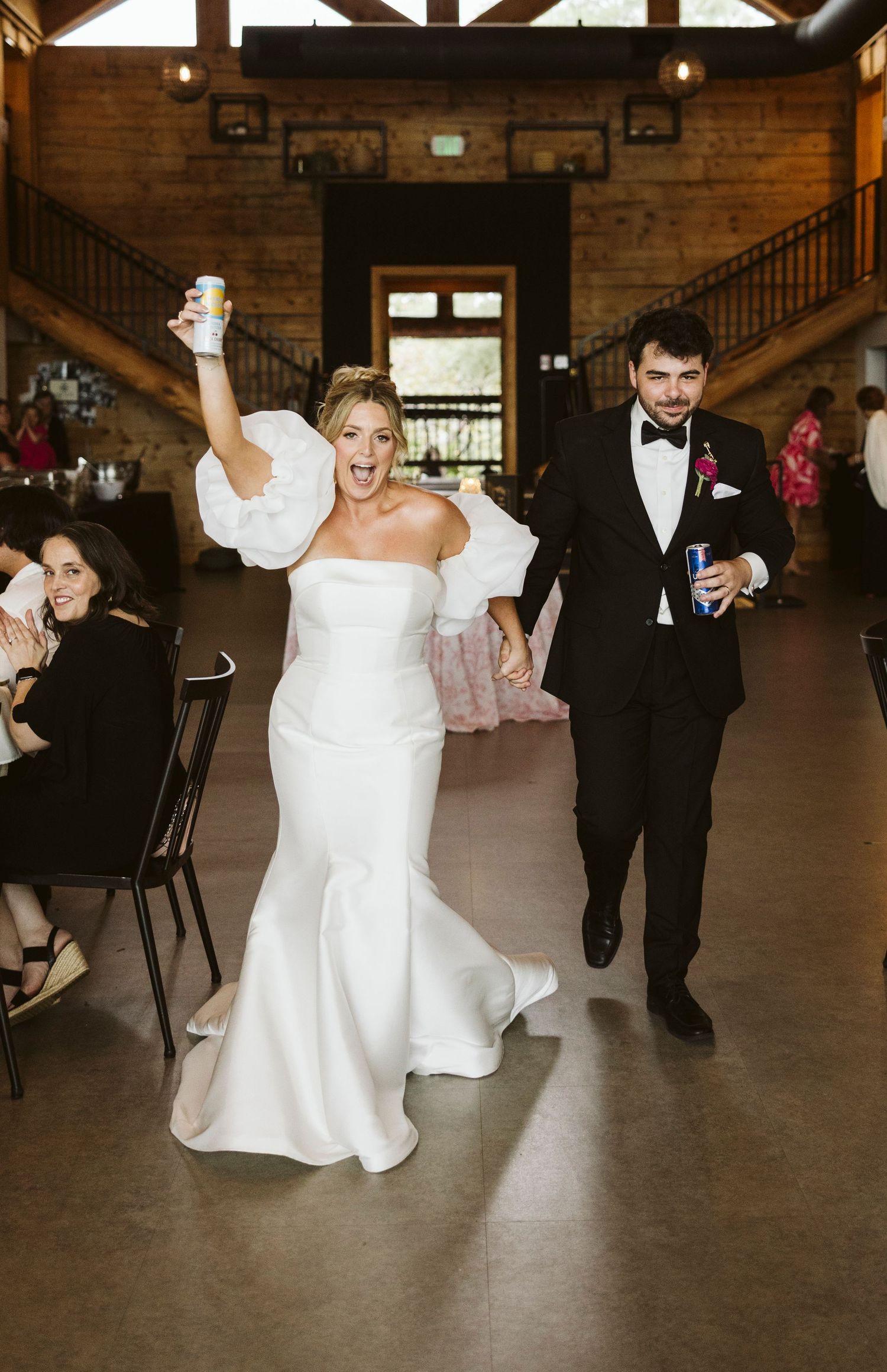 Wedding celebration with fun dance moves in a rustic brick-walled venue.