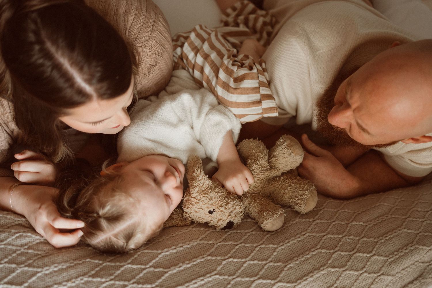 Cozy bedtime scene with stuffed animal and family members.