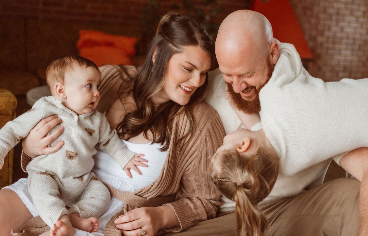 Series of warm toned family photos against red brick wall background.