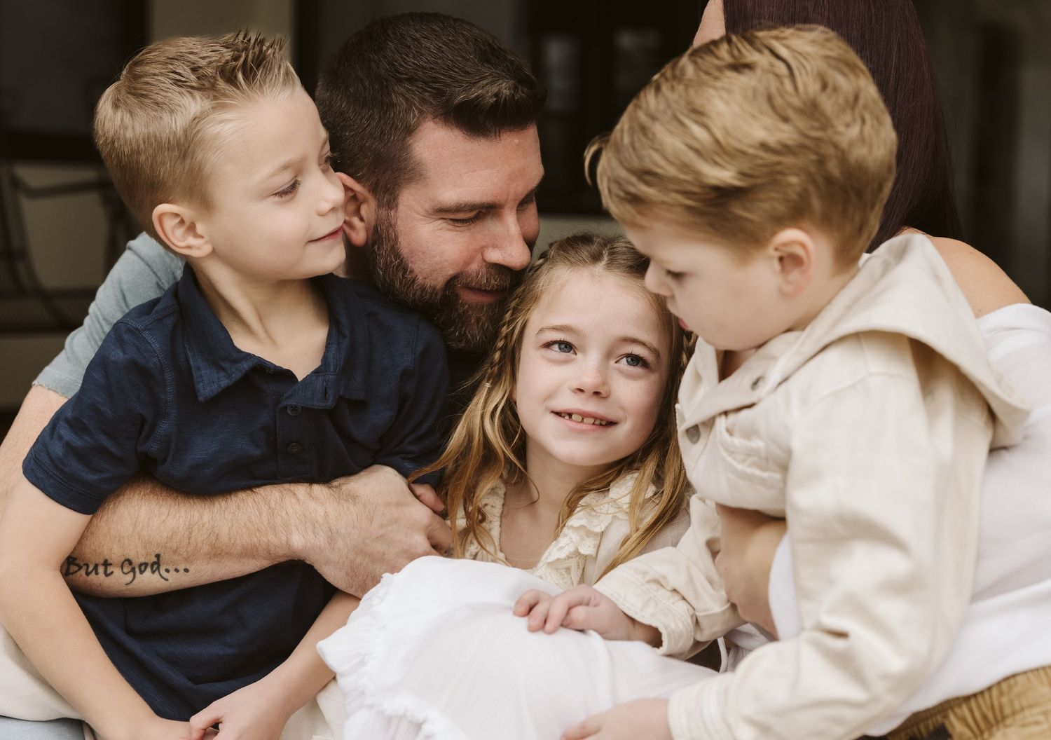 Intimate family portrait with children sharing loving moment.