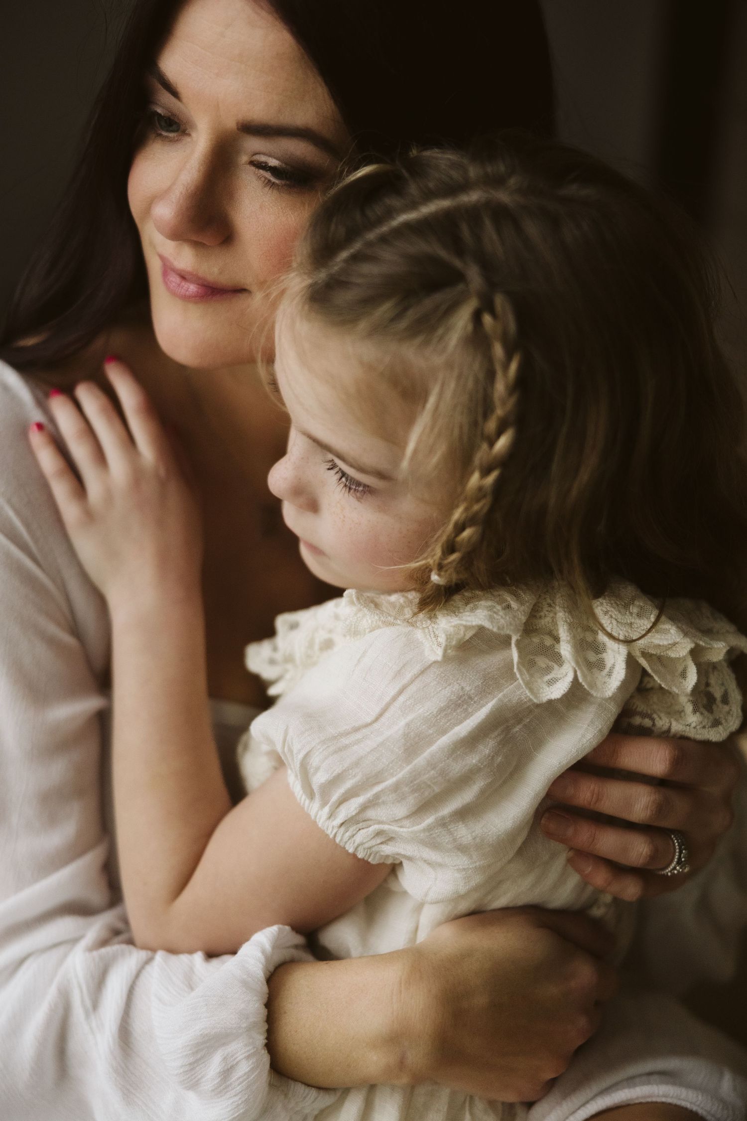 An intimate portrait featuring soft lighting and delicate white lace details.