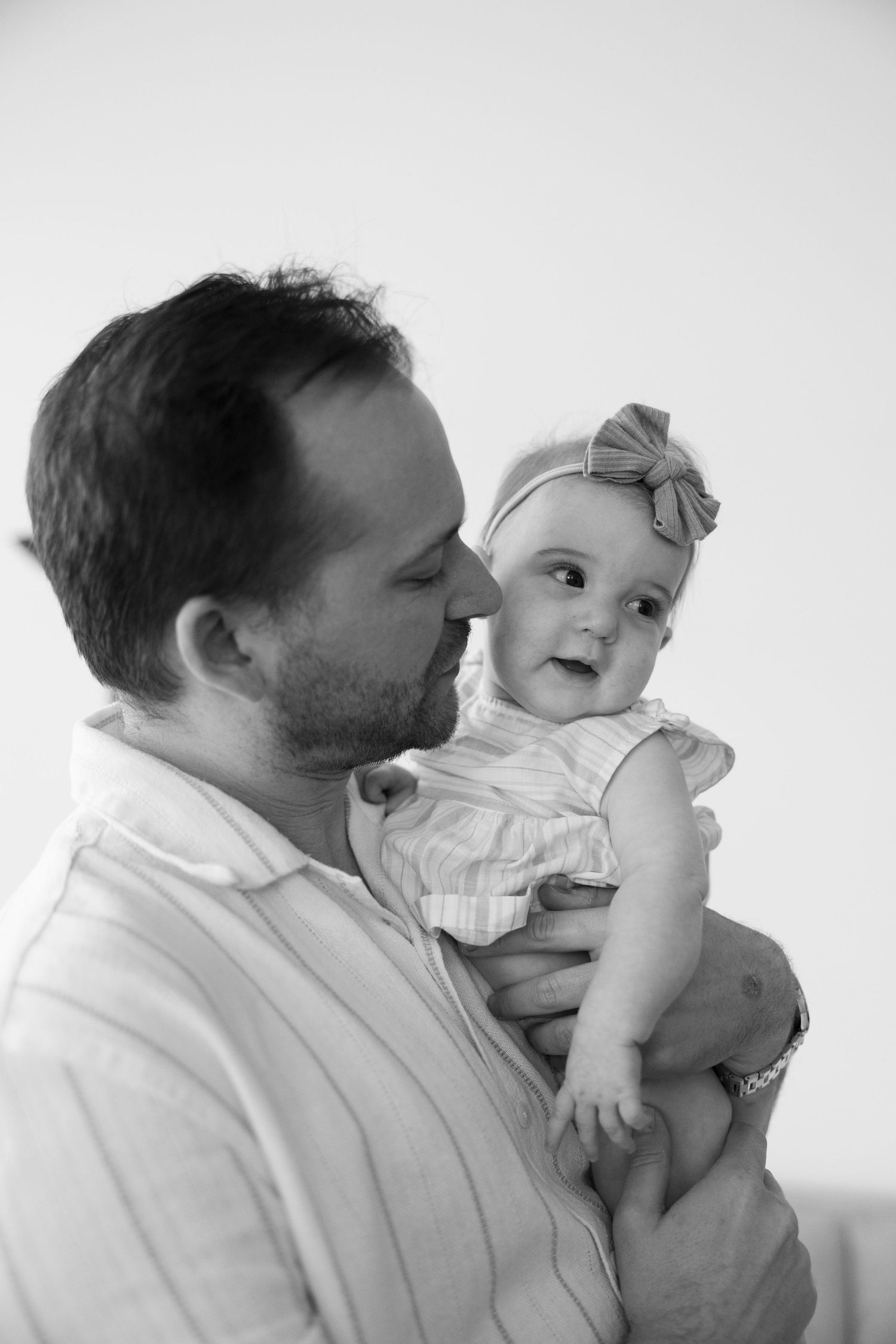 Sweet candid moments between a parent and baby in black and white.