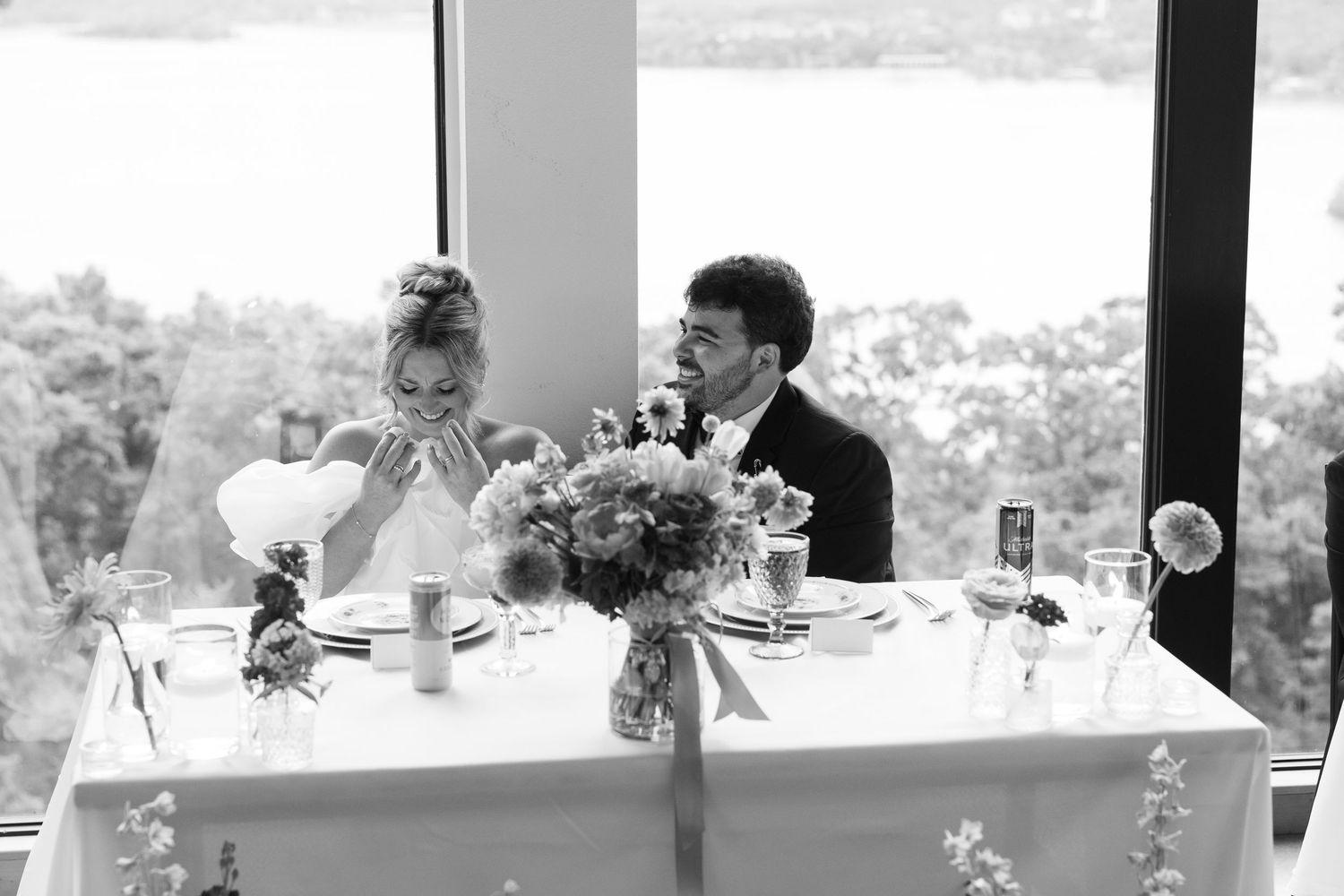 Elegant indoor wedding reception venue with floor to ceiling windows overlooking scenic landscape.