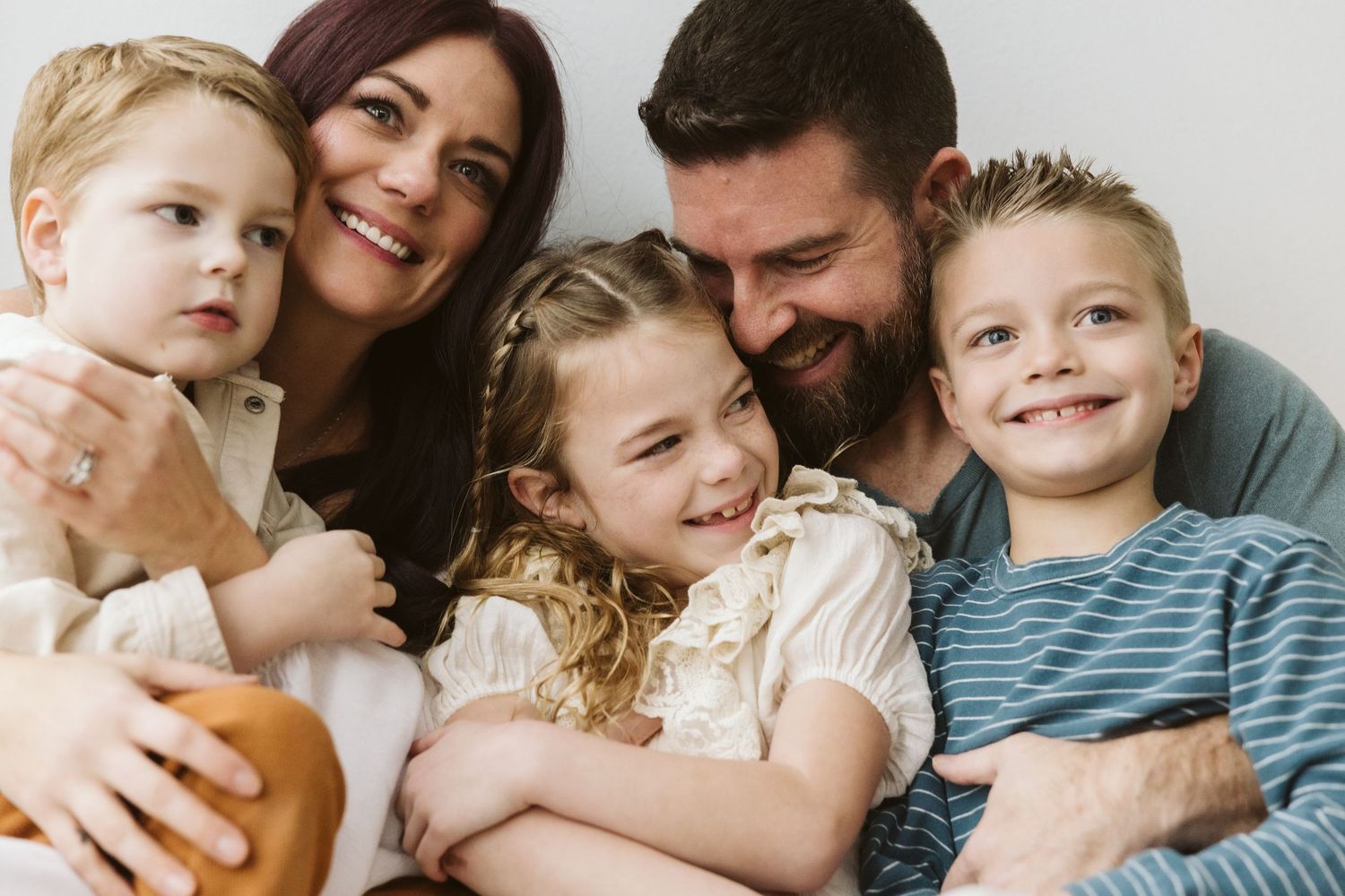 Close-up portrait of a family sharing genuine smiles and laughter together.