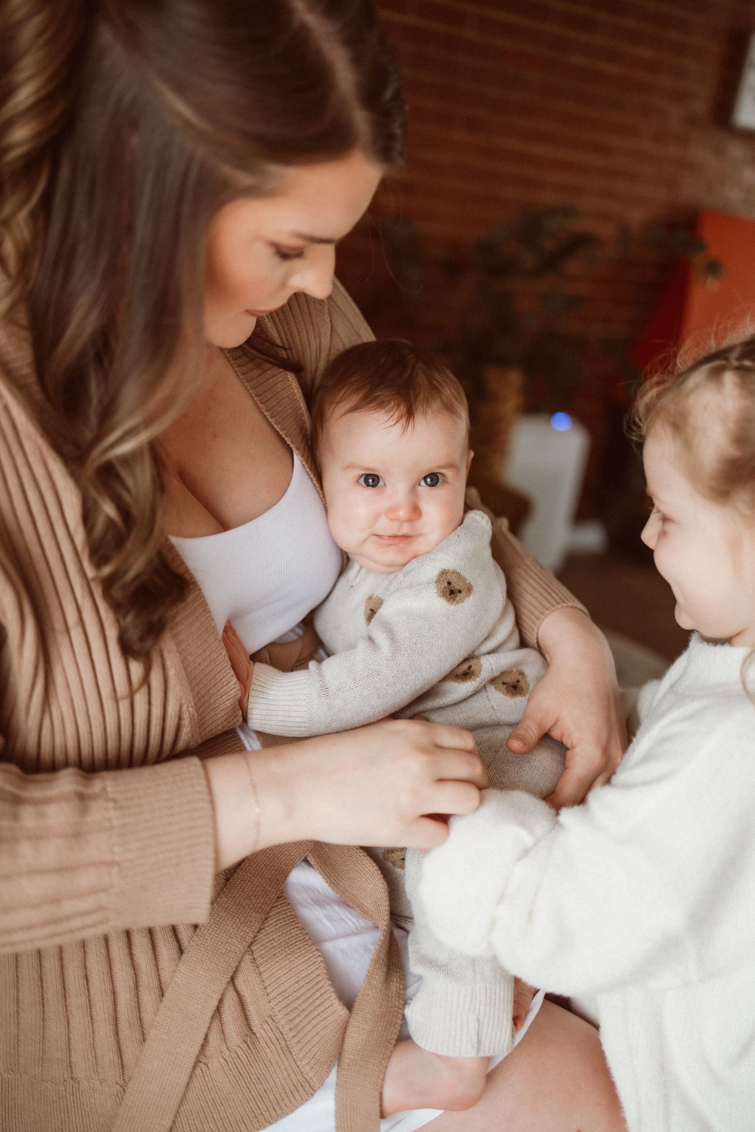 Intimate family portrait session showing tender moments between parents and children on a couch.