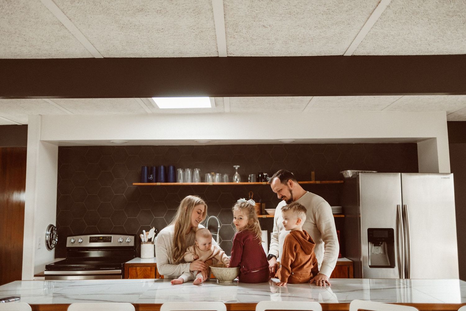 Family gathering in modern kitchen for casual conversation and bonding time.
