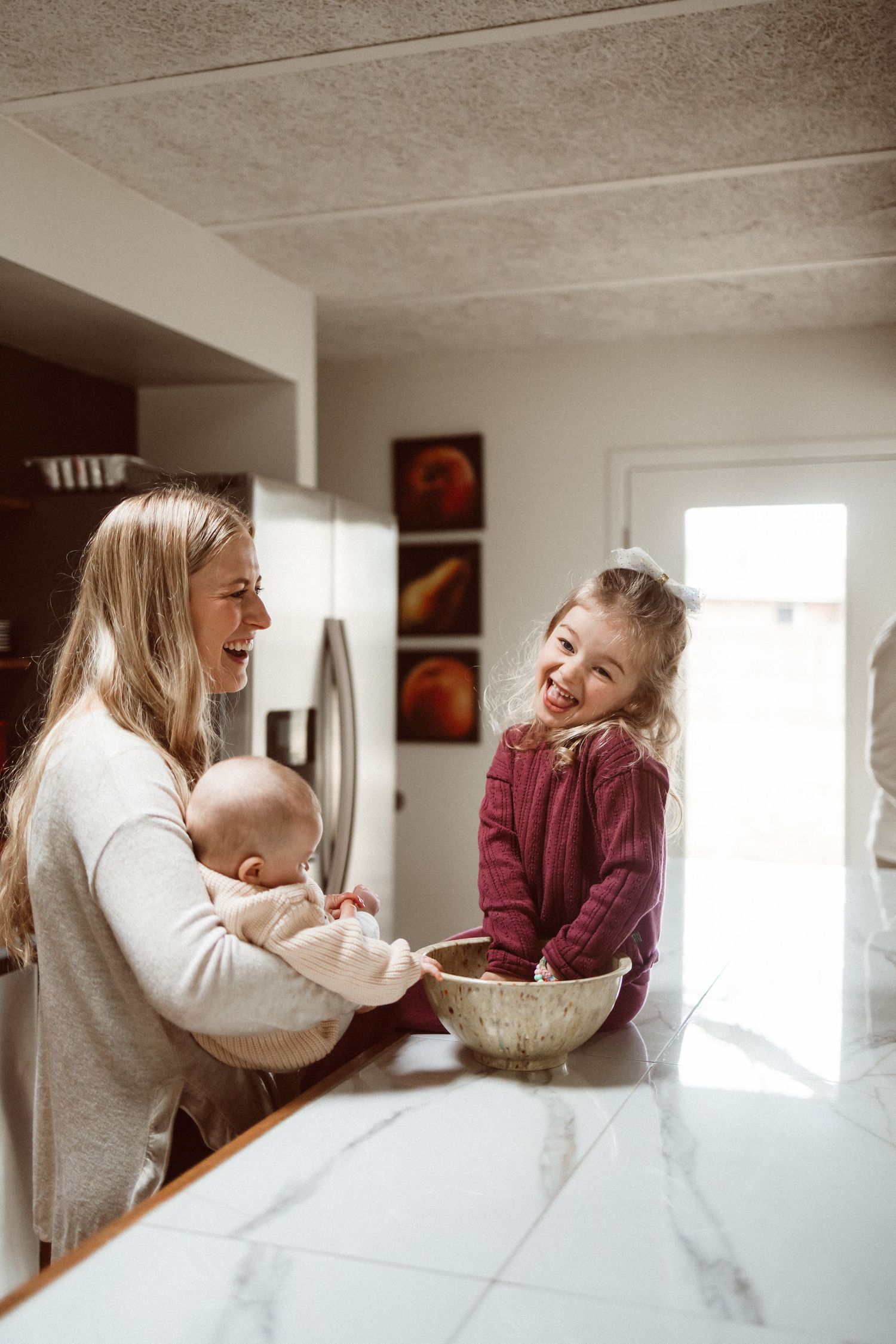 Mother and child baking together at marble kitchen counter.