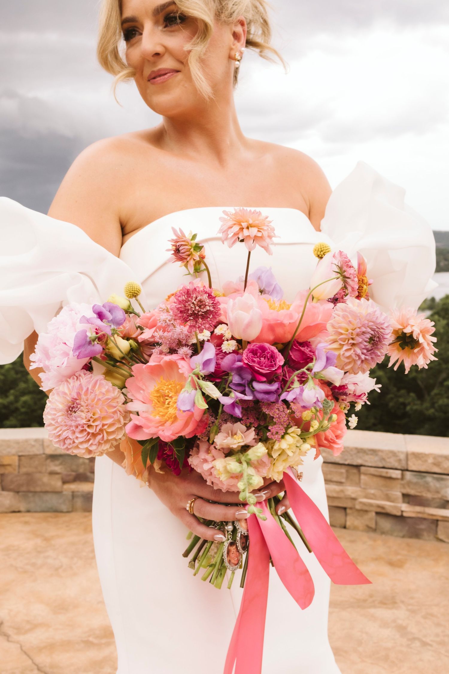 A vibrant wedding bouquet featuring pink and purple flowers with flowing ribbons.