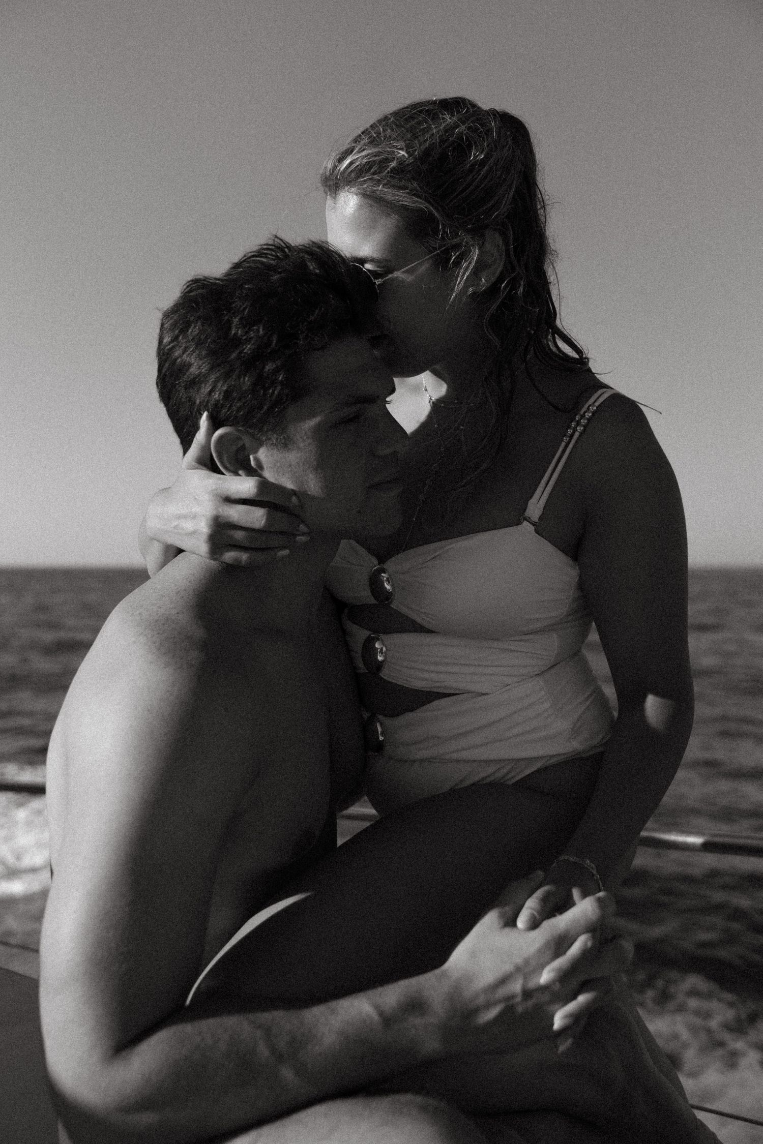 Black and white photo capturing a couple together on a boat at sea in Crete, Greece.