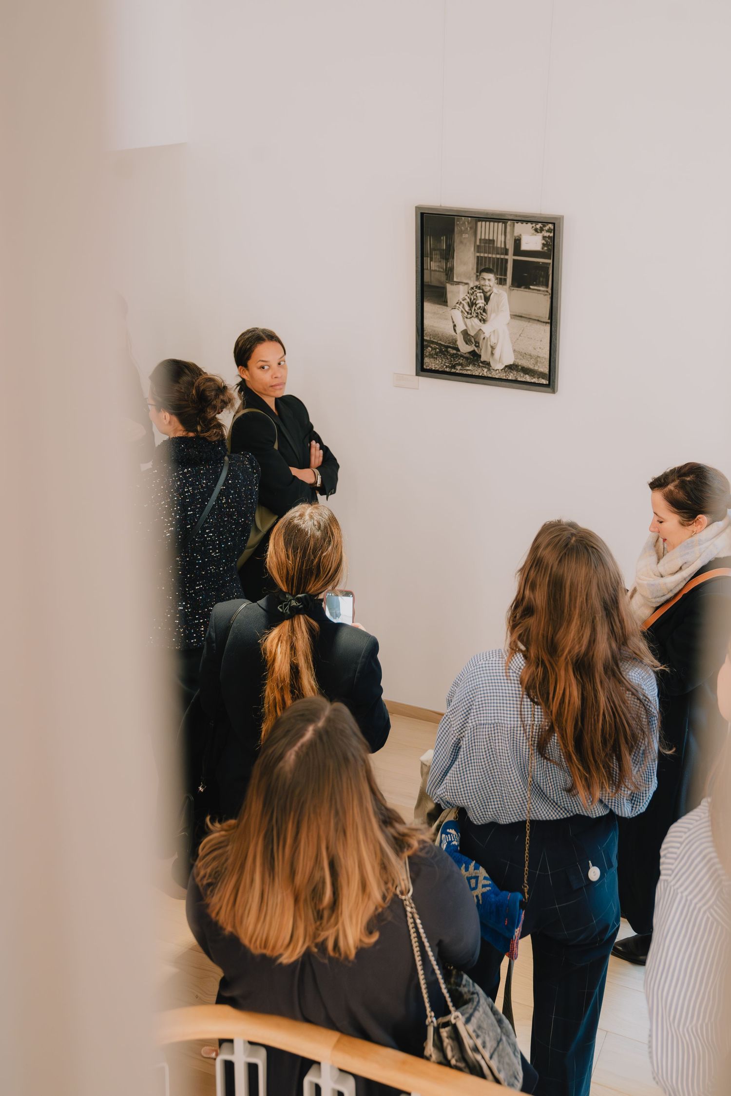 Paris event photo of guests listening during intimate talk on an art tour, candid editorial moment with warm storytelling tone