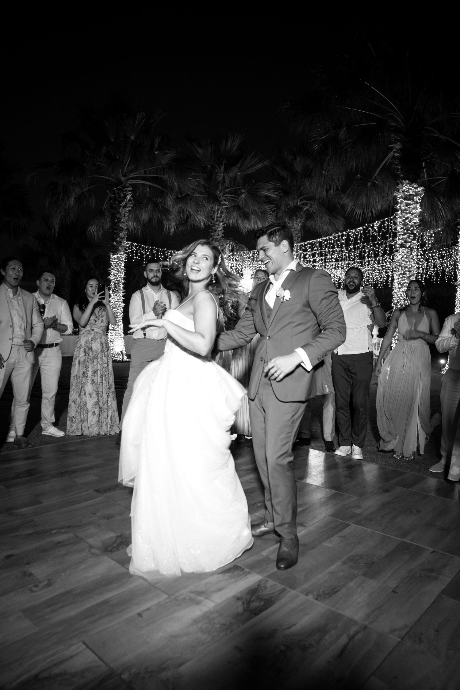 A series of black and white photos showing couples dancing at a wedding reception on a wooden dance floor.