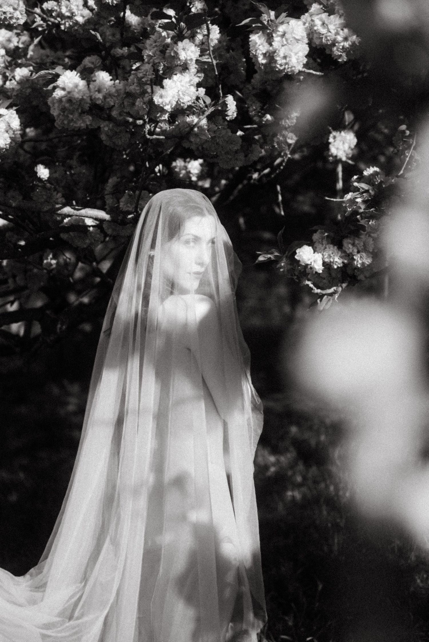 Editorial bridal portrait in Paris, black and white film-inspired image with veil & flowers, romantic wedding photography by Studio Reverie