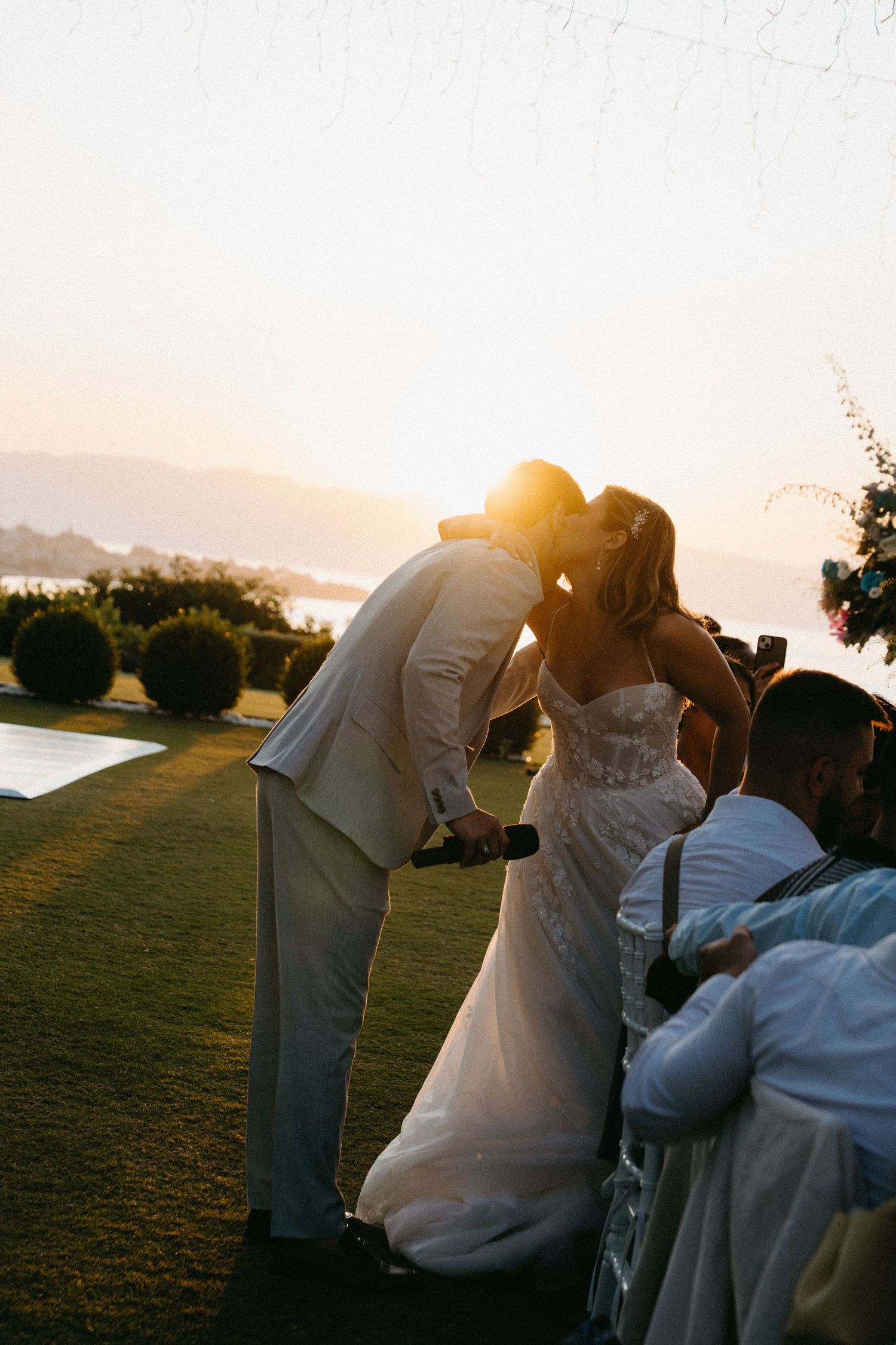 A romantic sunset wedding ceremony moment captured in a series of photos showing a couple's first kiss.