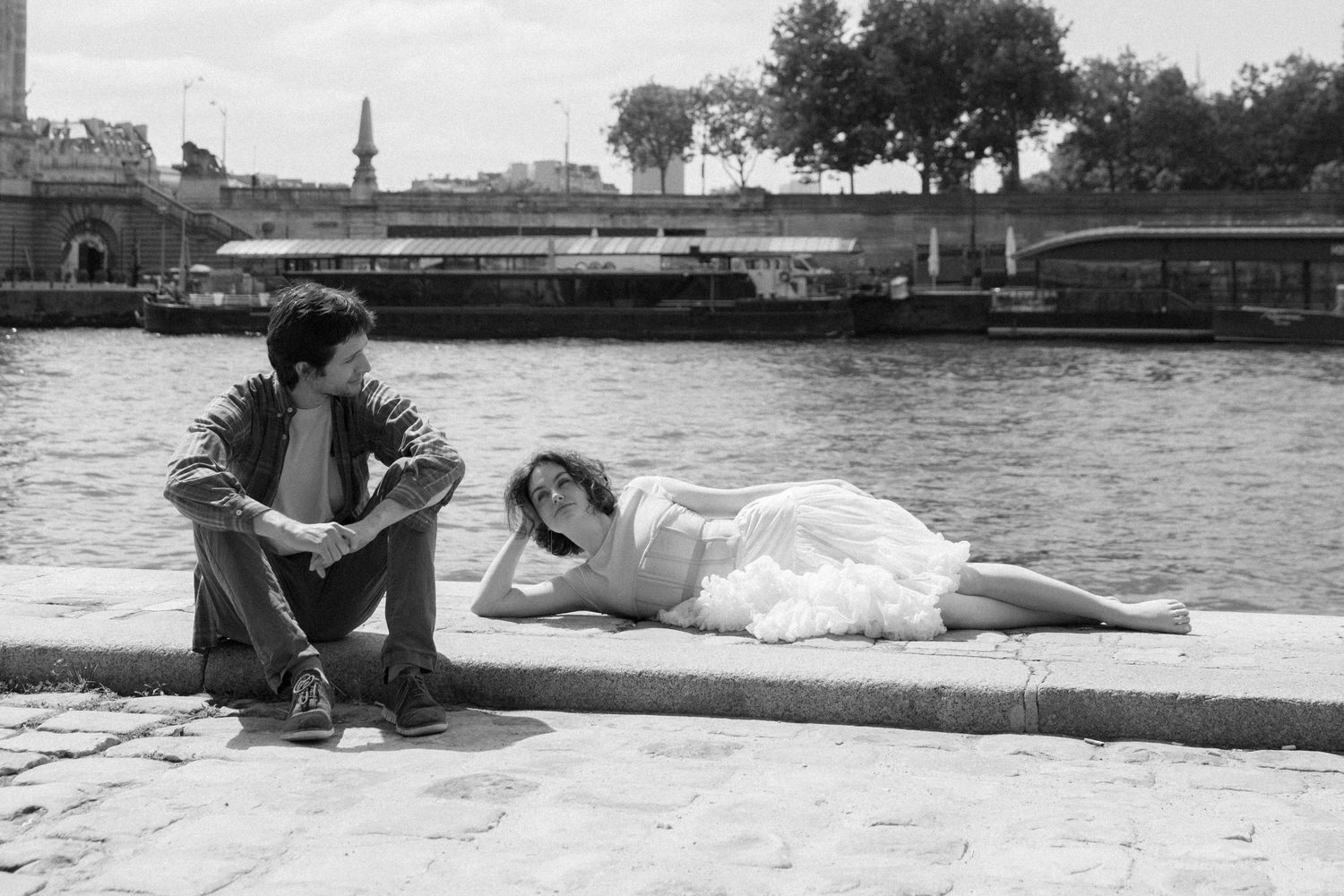 A black and white photo series showing a person sitting on a dock by a body of water.