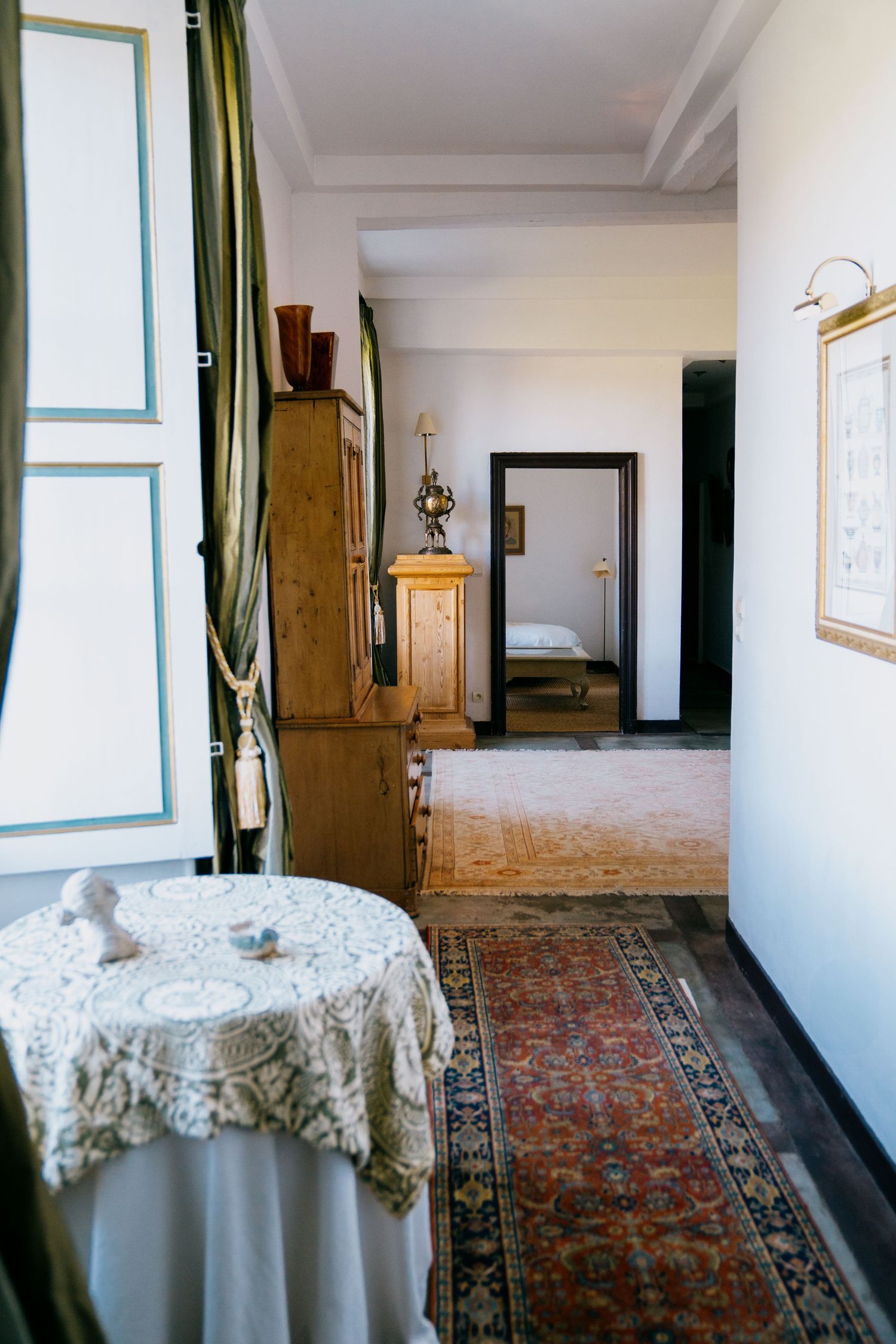 A series of interior views showing an elegant room with oriental rugs, white walls, and lace-covered round tables.