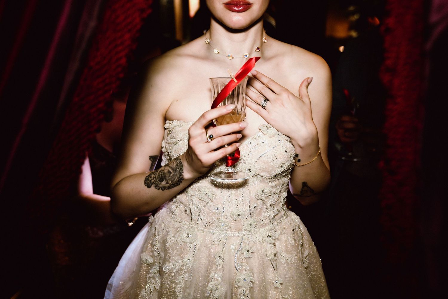 Close-up shots of a person wearing an elegant white lace wedding dress with red lipstick.