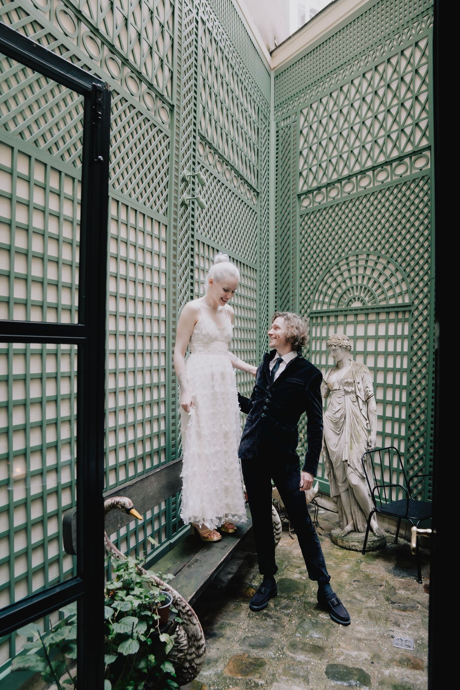 Editorial wedding couple at Maison Souquet in Paris, playful moment in ornate courtyard, unique destination photography by Studio Reverie.