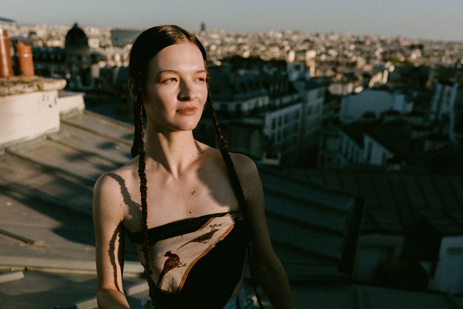 Artistic portrait series showing a person in golden sunlight against urban rooftop backdrops at sunset.