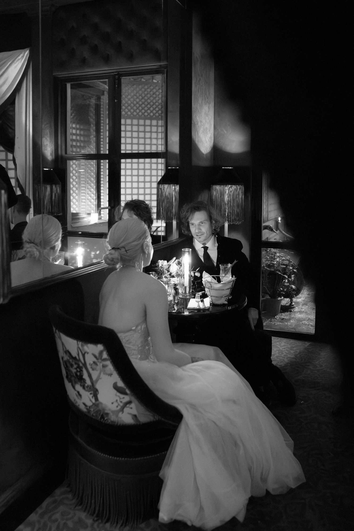 Intimate candlelit scene in vintage setting with elegant formal attire.