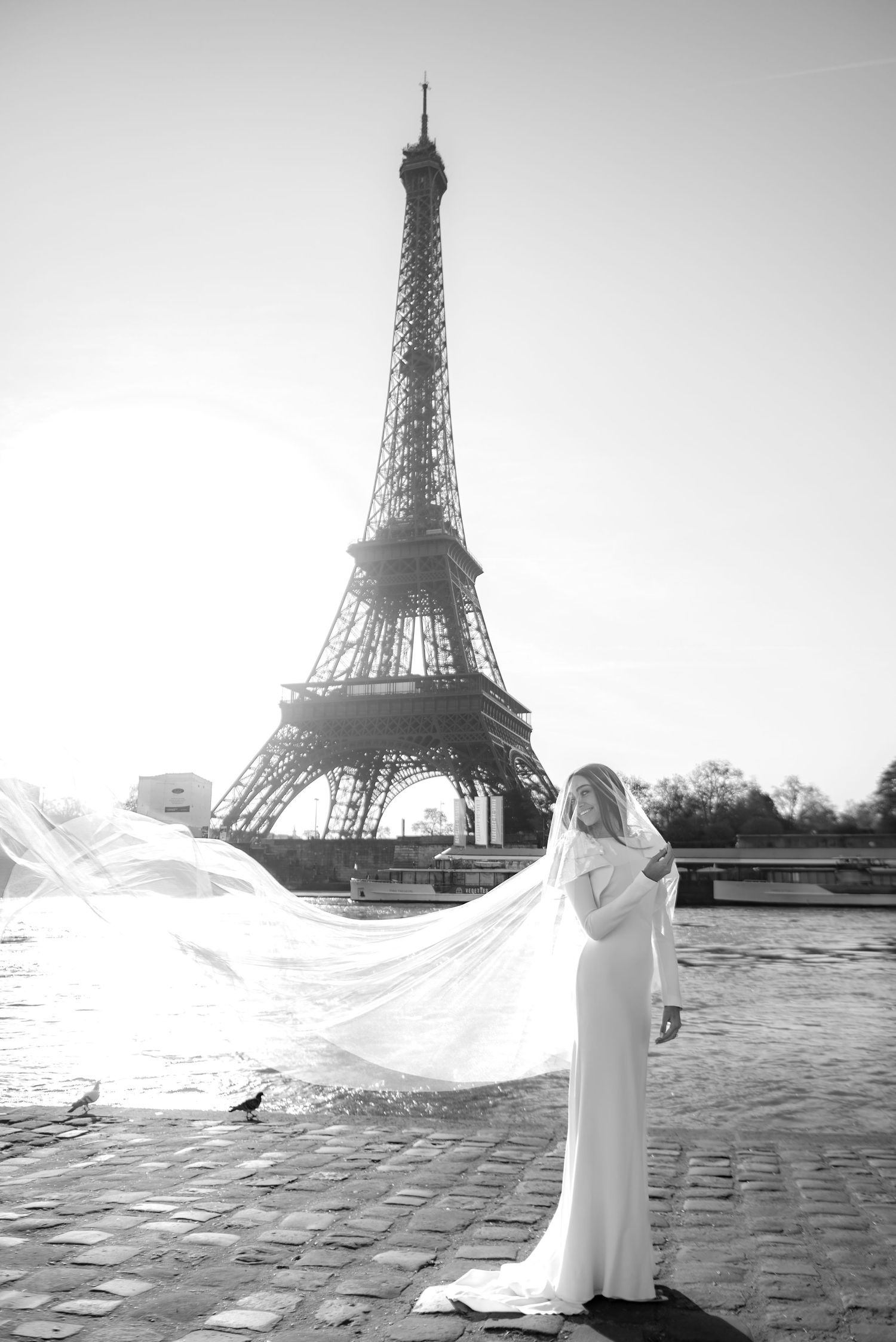 Editorial bridal portrait in Paris with cinematic veil and Eiffel Tower at sunrise, captured in a natural unposed style.