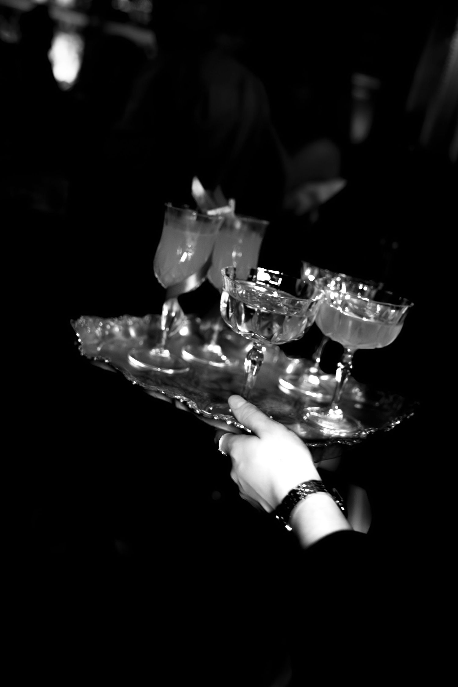 Candlelit scene showing hands lighting multiple candles in a dark atmospheric setting.