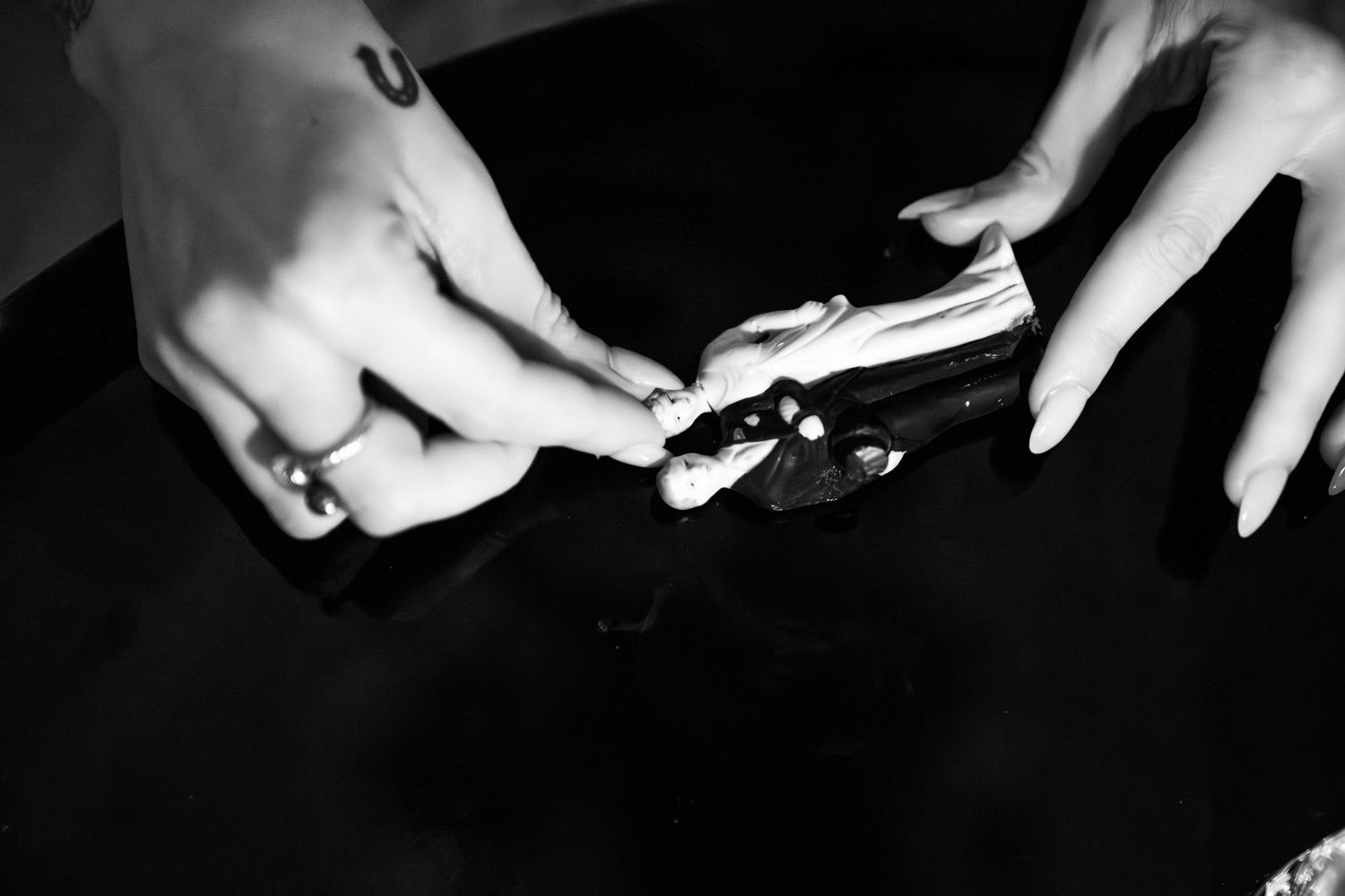 Black and white close-up shots of hands against a dark background.