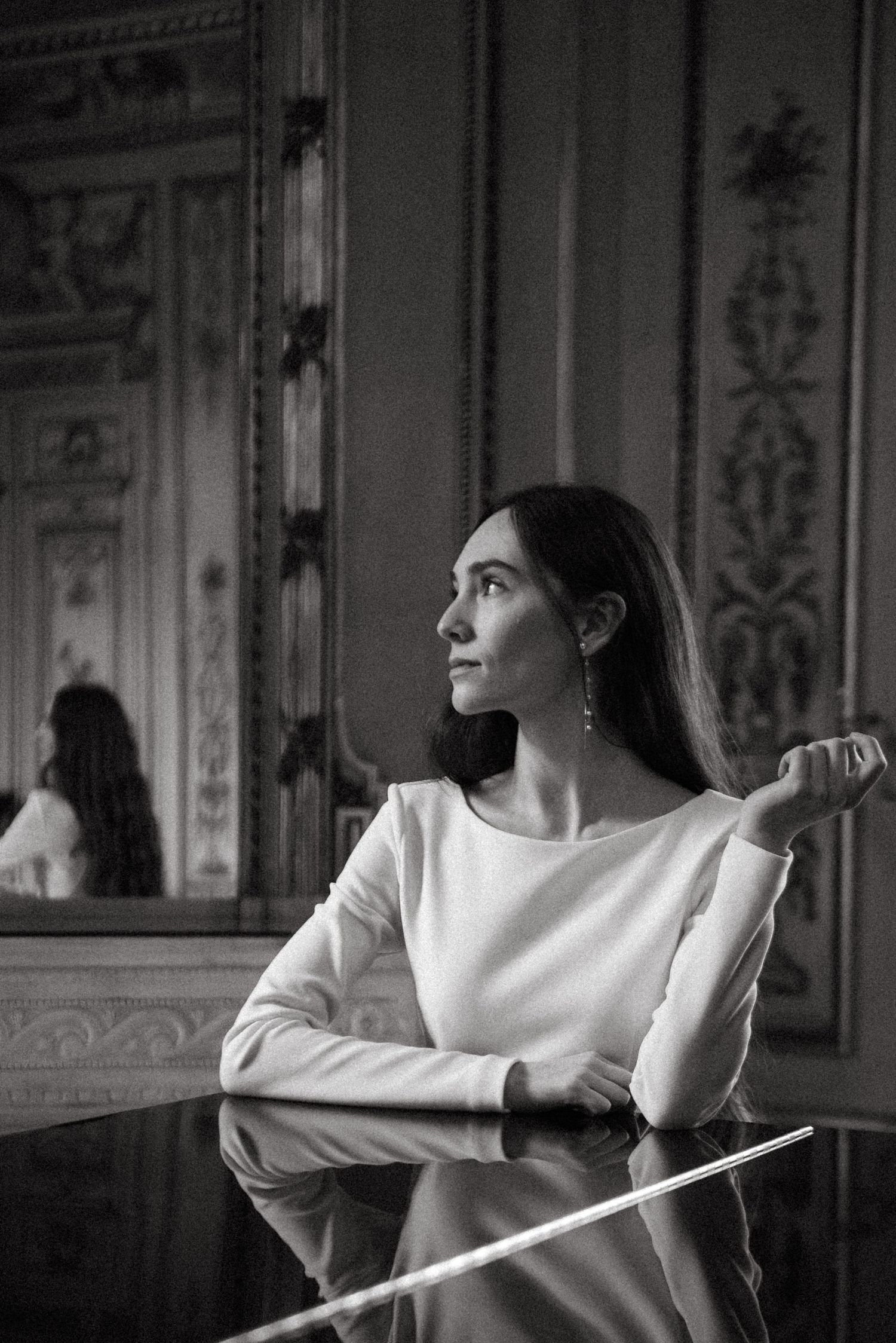 Elegant interior scene in black and white with ornate wall details and dramatic lighting.