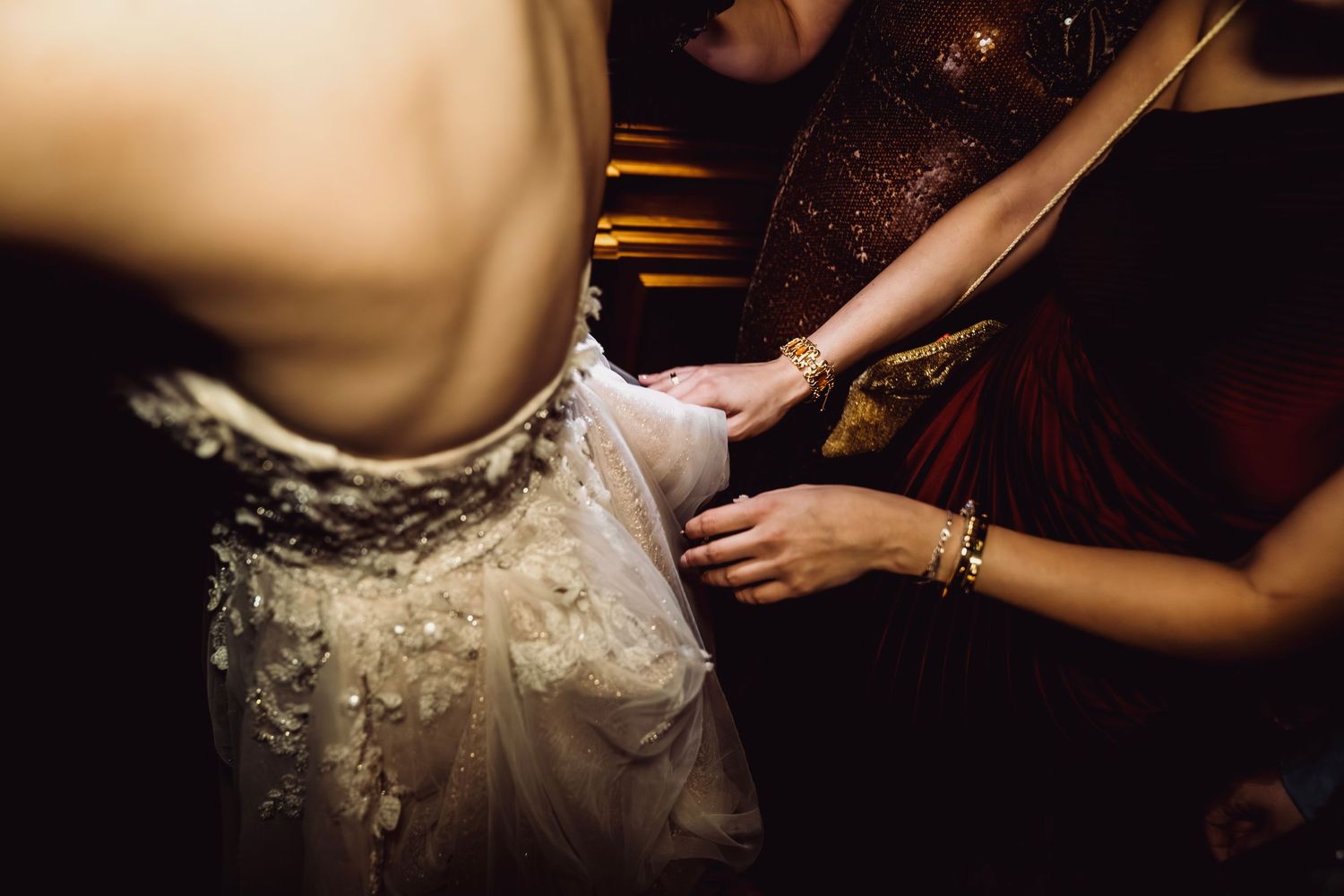 Detail shots of a bride's white lace wedding dress with intricate beading and embellishments.