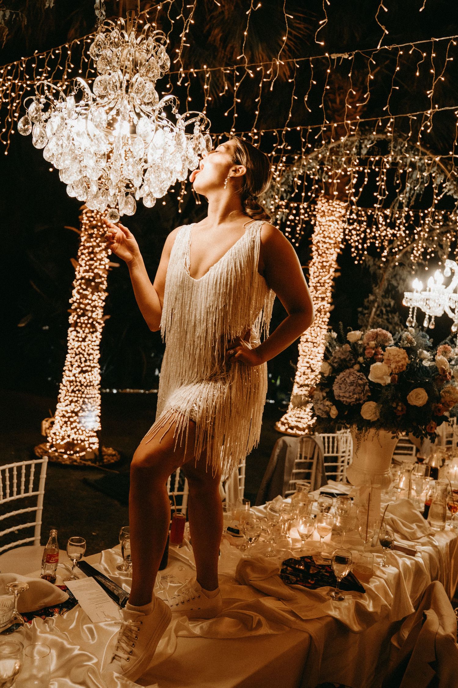 Wedding reception venue decorated with hanging fairy lights and elegant table settings.