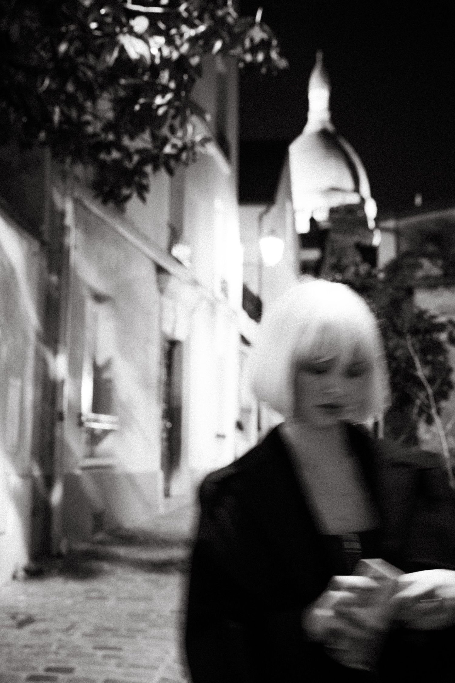 Cinematic black and white fashion portrait in Montmartre at night, moody with Sacré-Cœur in background, photography by Studio Reverie