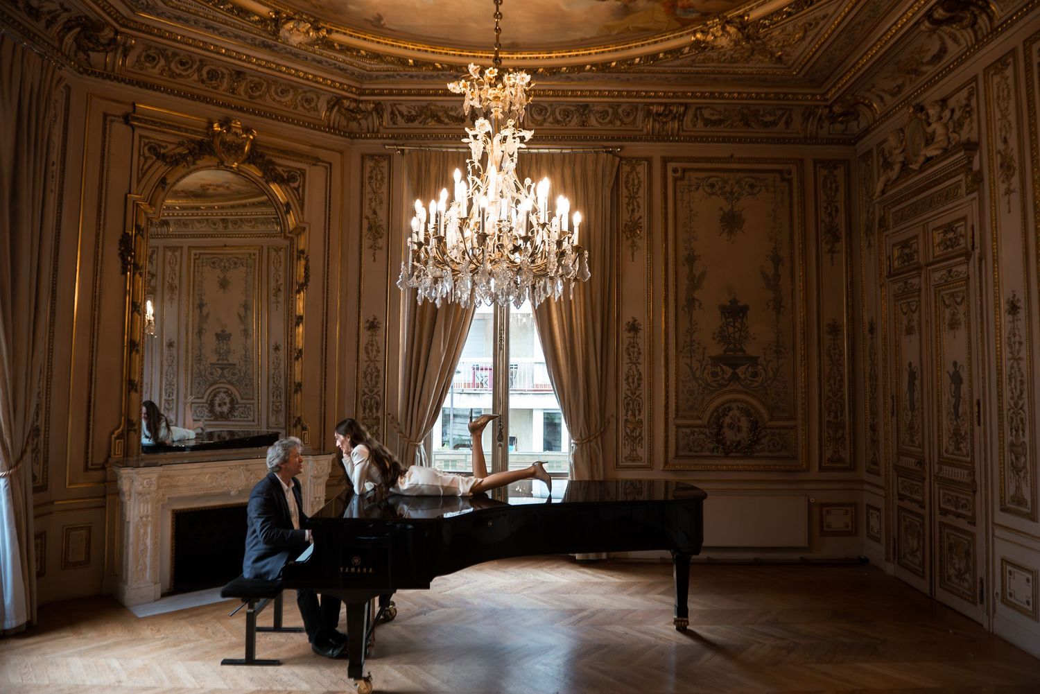 Editorial couple portrait in Paris with chandelier and grand piano, intimate and cinematic moment in ornate room