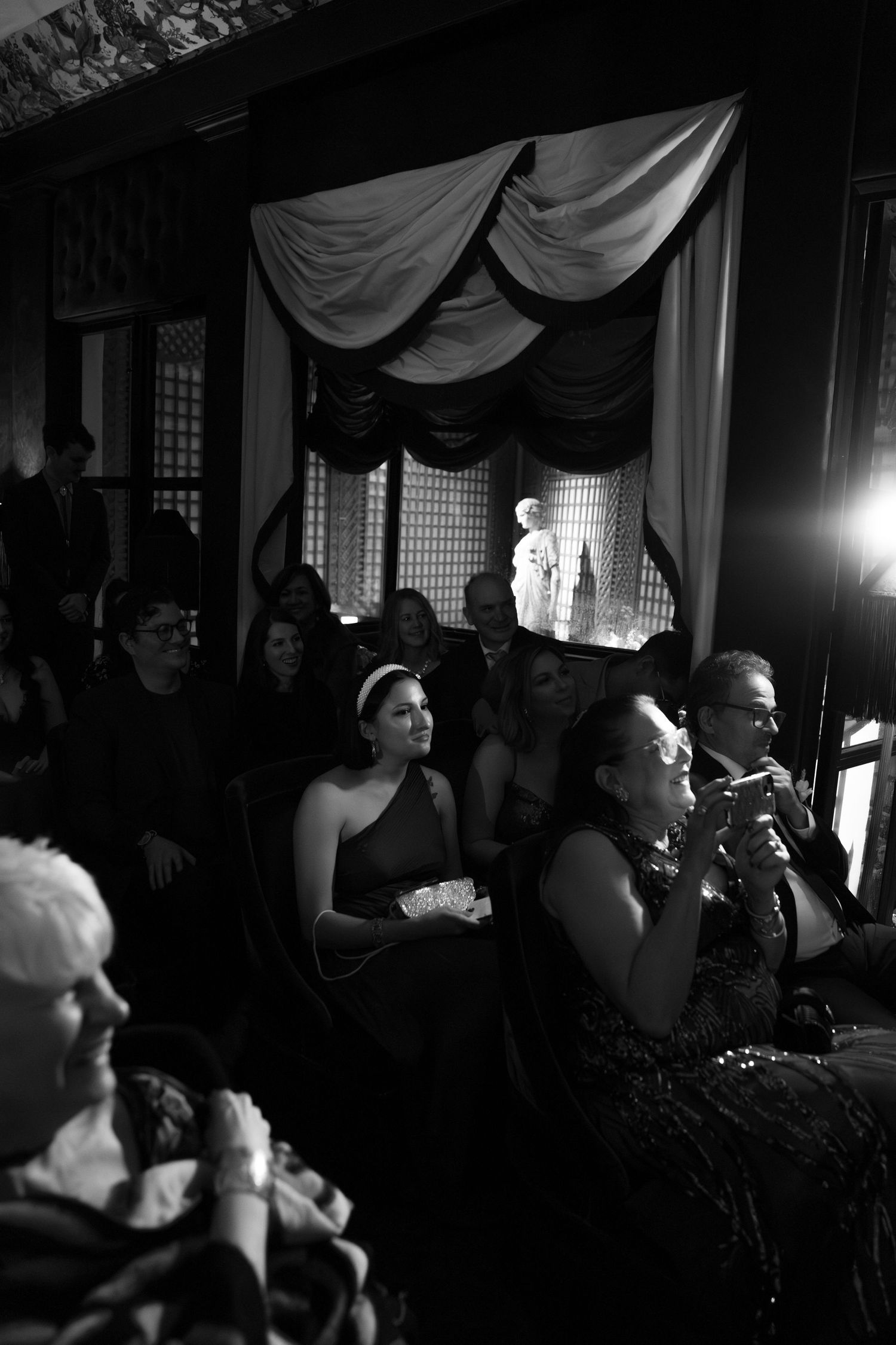 Dark moody reception scene with dramatic lighting and draped fabric decor.