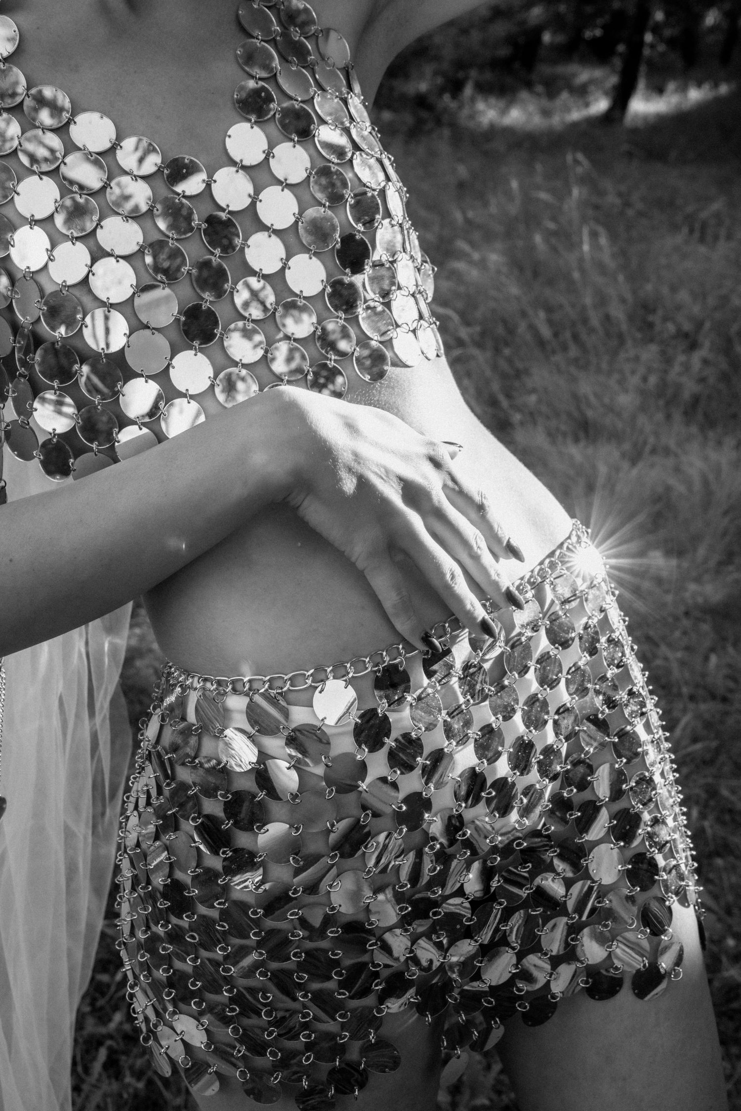 Editorial detail of mirrored sequin bridal look with hand on waist, modern fashion-forward wedding style in natural light.