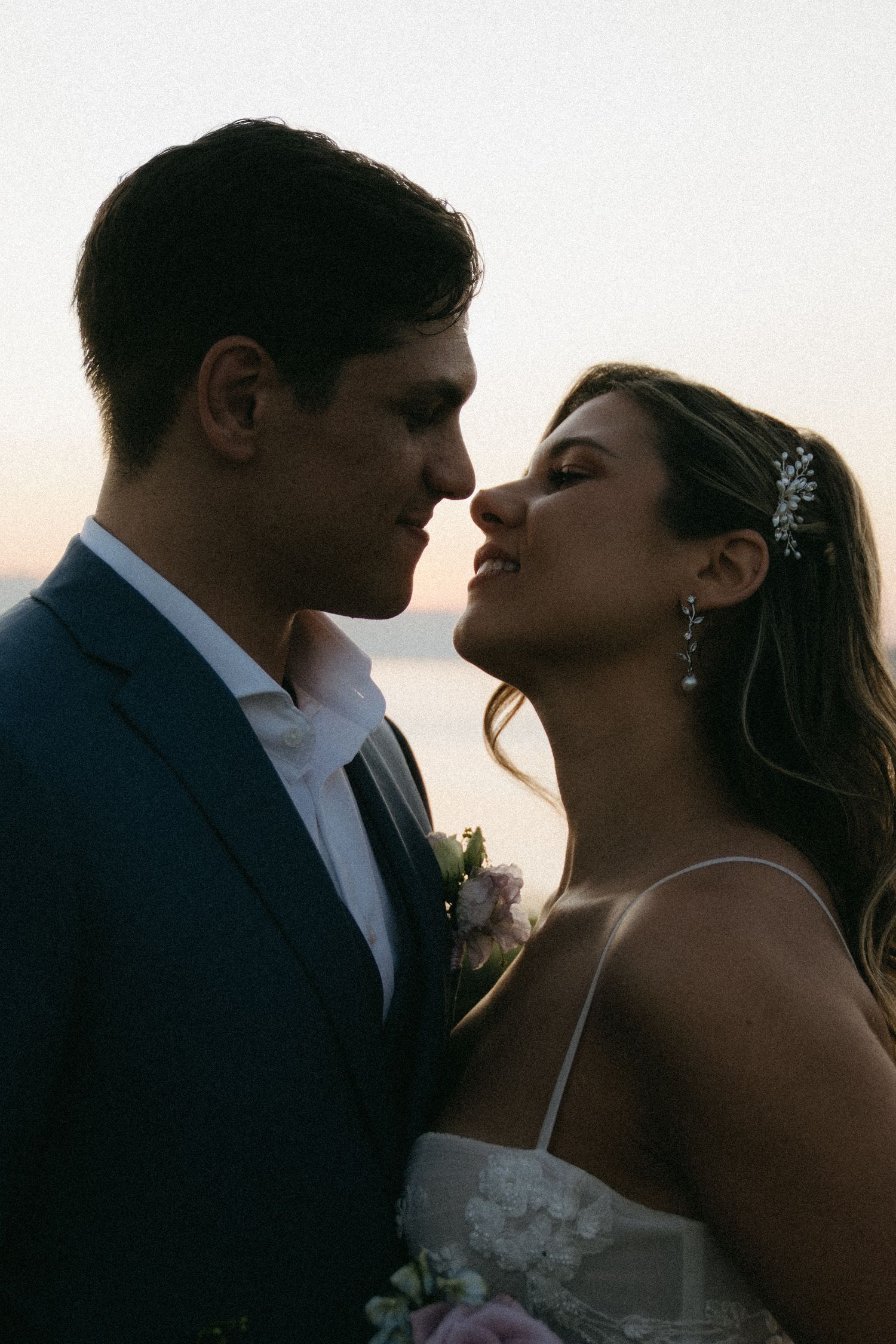 Silhouette of a romantic couple in formal attire during sunset creating an intimate moment.