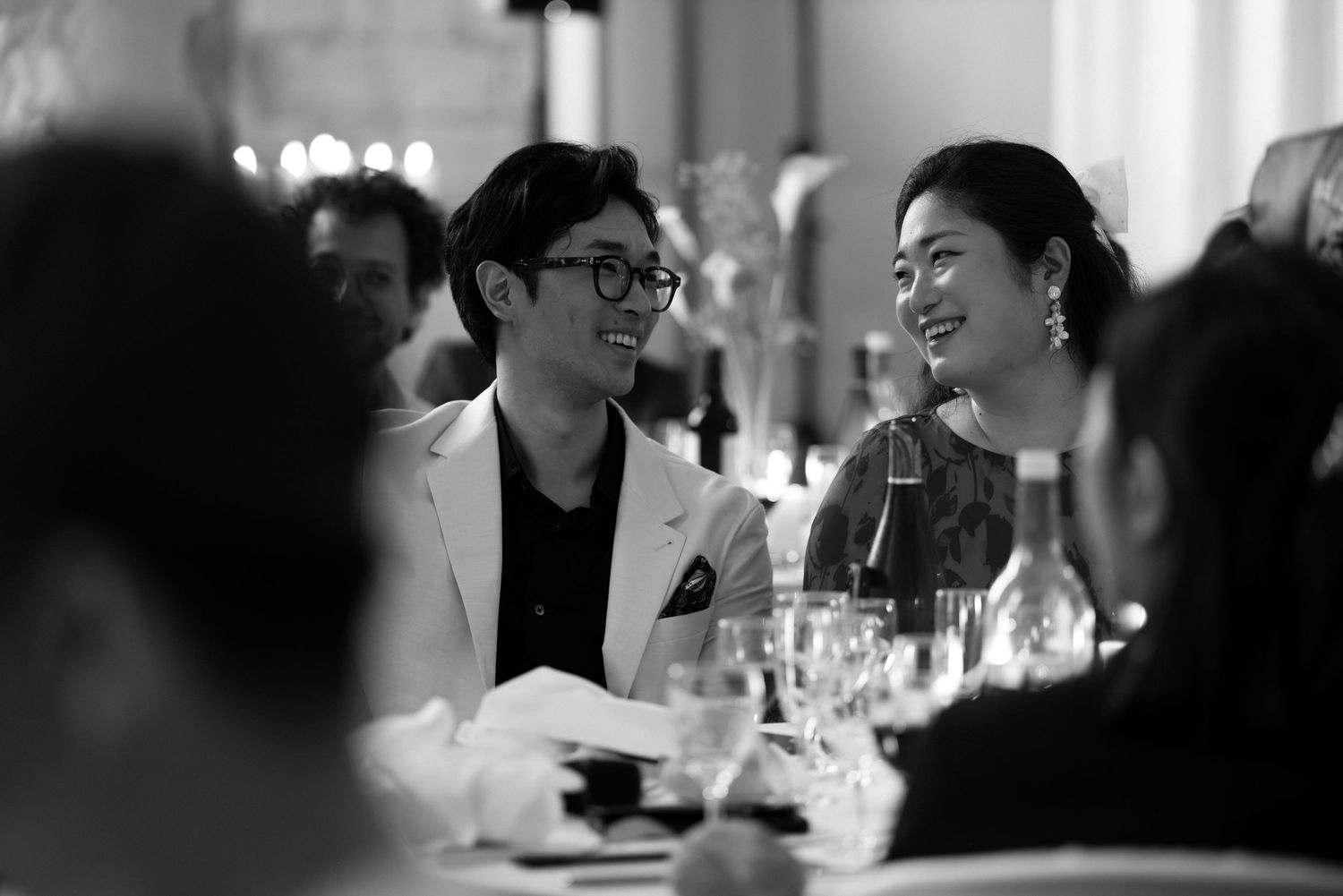 Black and white candid shots of wedding reception guests dining and socializing at decorated tables.
