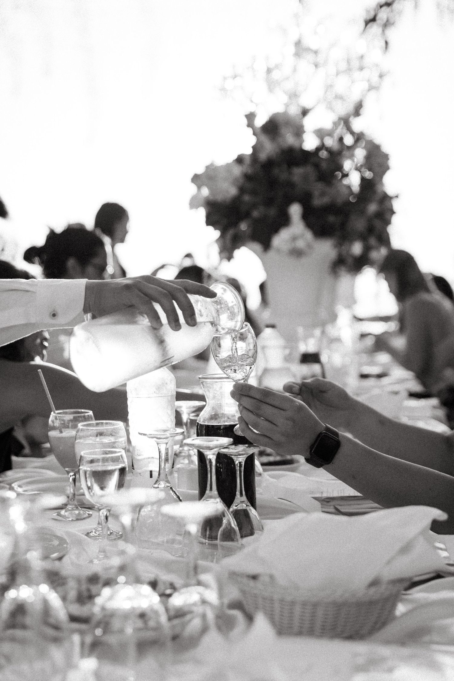 Black and white image of a wedding reception table setting with glassware and place settings.