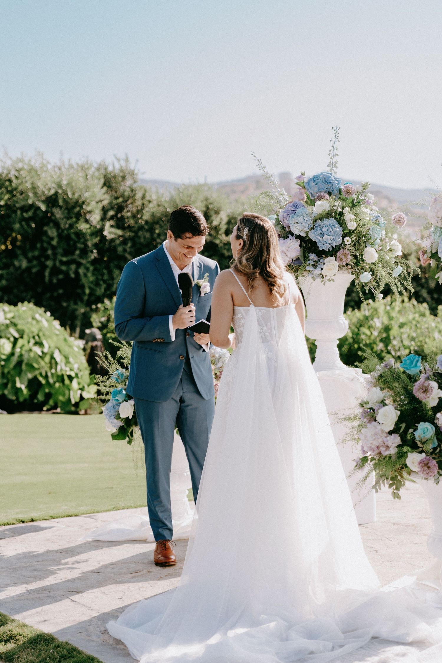 A romantic outdoor wedding ceremony setup with floral arrangements and mountains in the background.