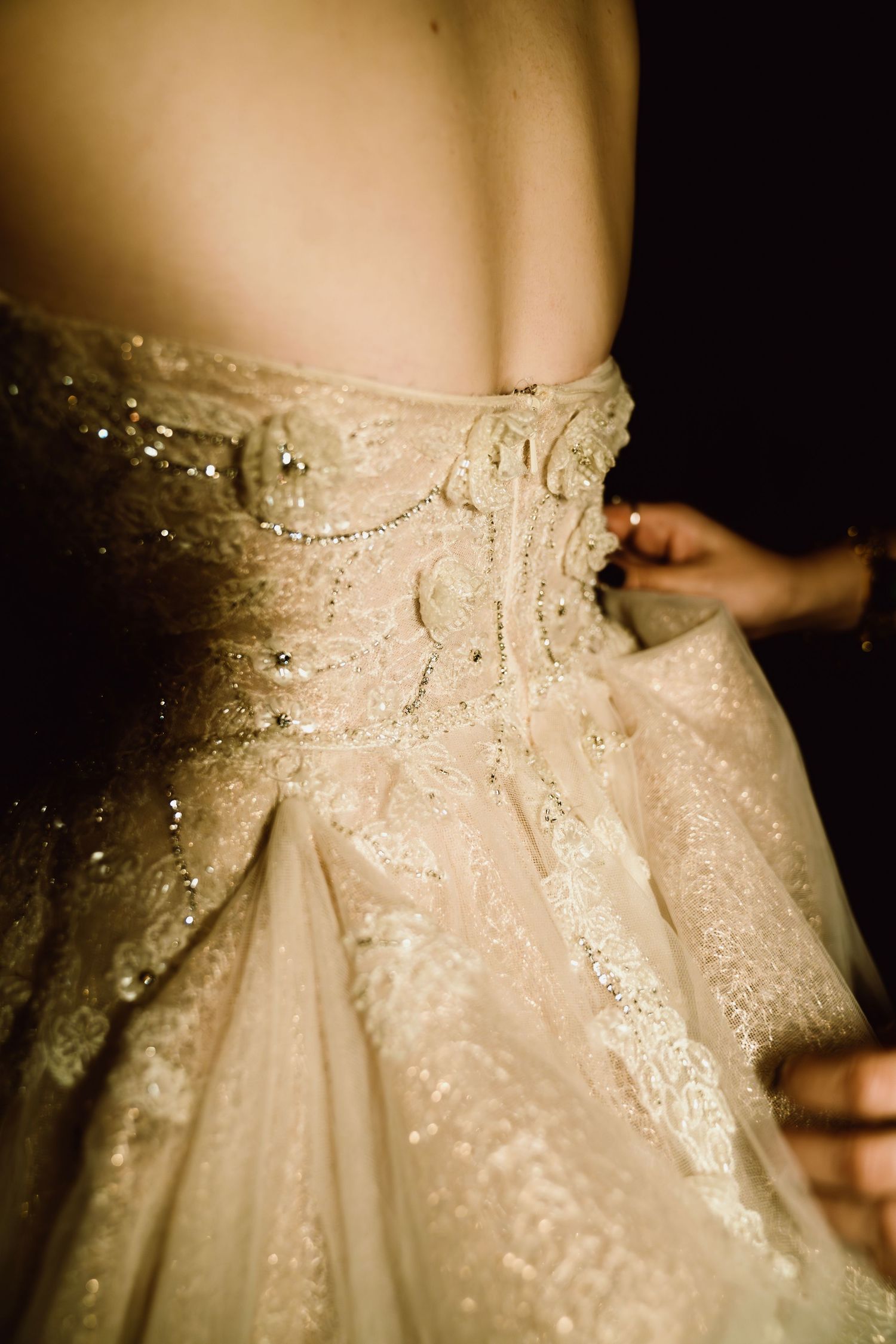 Close-up detail of a sparkly champagne-colored wedding dress with intricate beading.