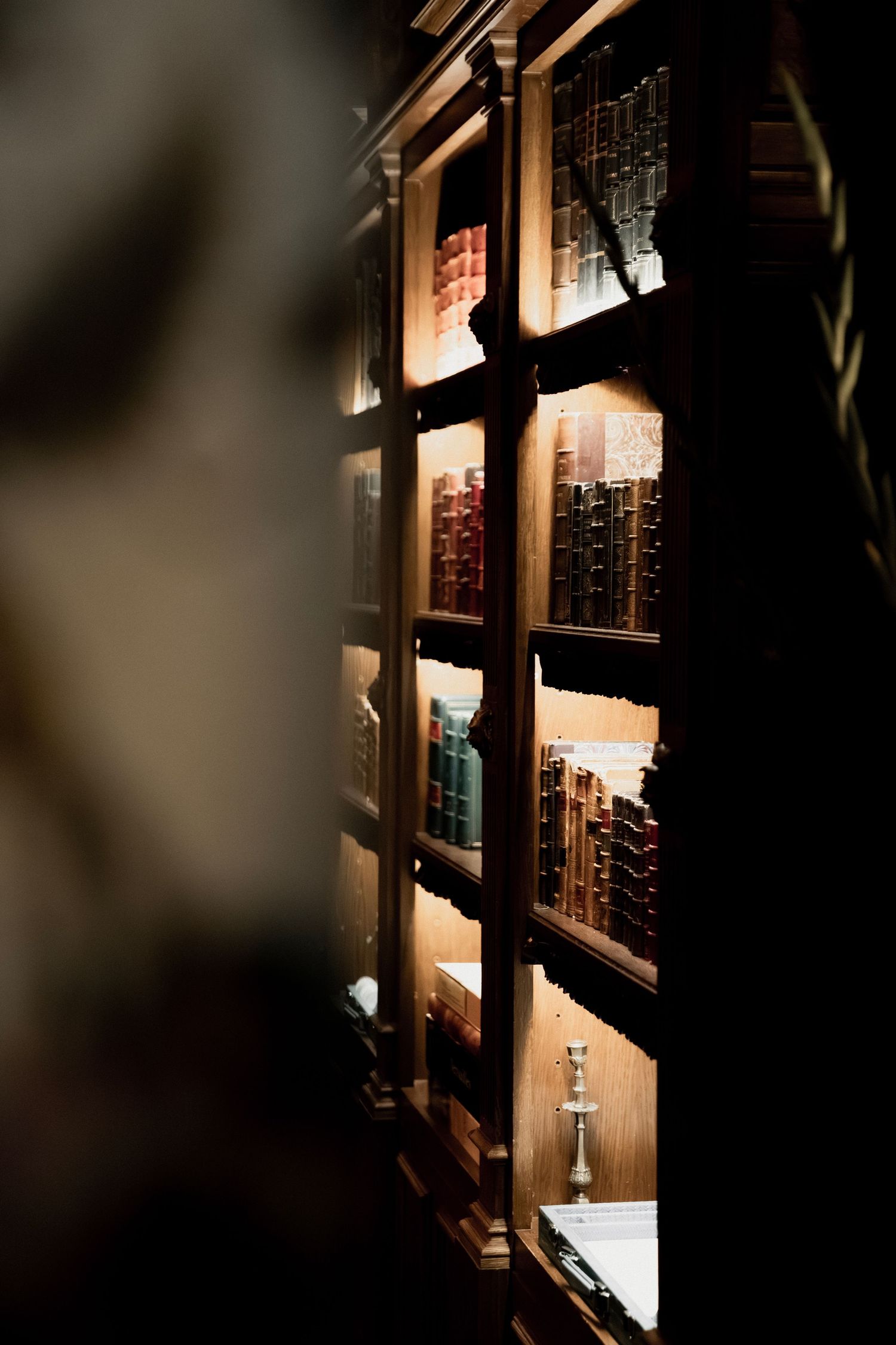 Dramatic lighting in a dark corridor with illuminated wall fixtures casting shadows.