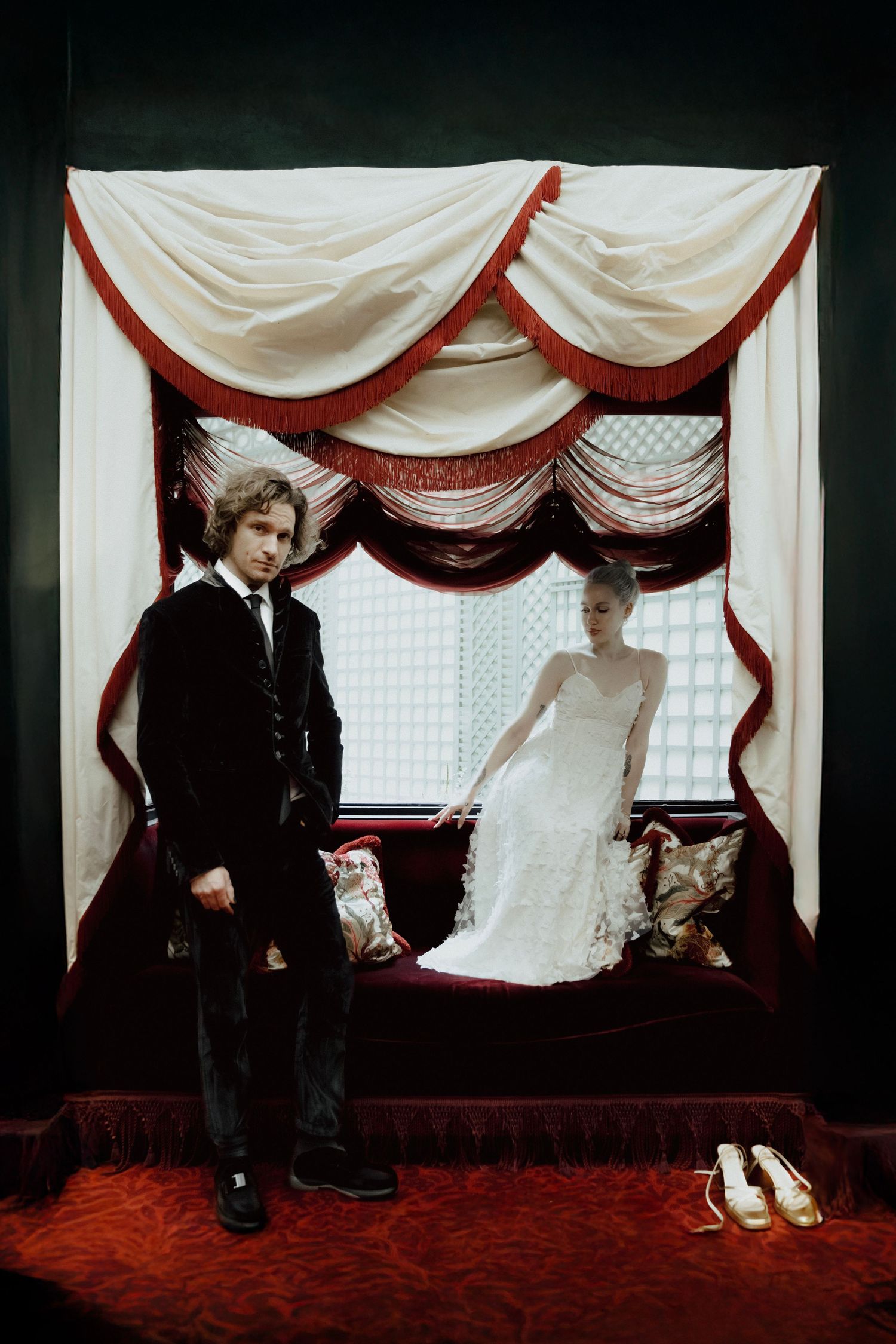 Wedding scene with white and red draped curtains and red carpet setting.