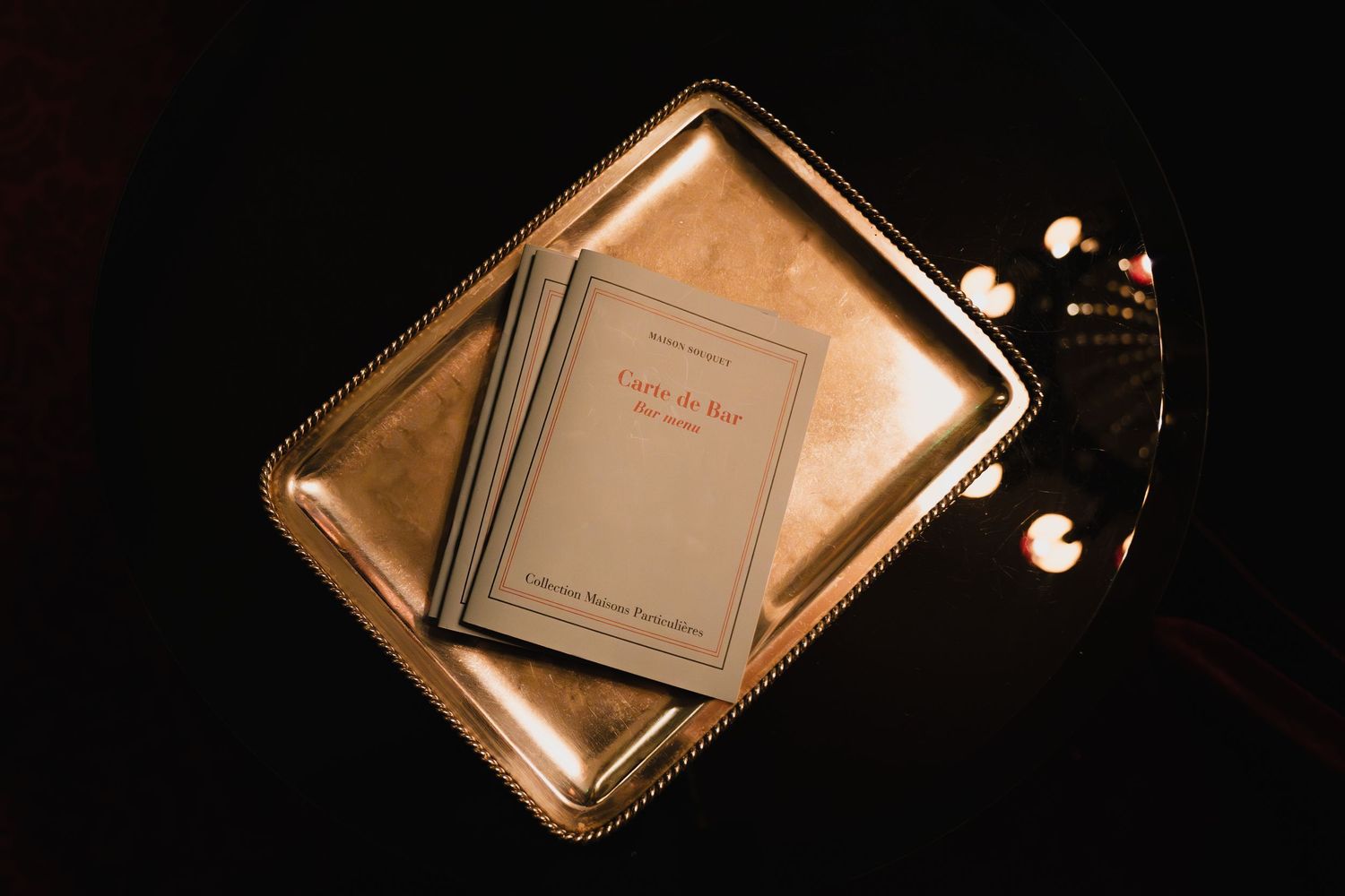 Metallic gold book covers or album covers arranged in a row showing reflective surfaces in dark lighting.
