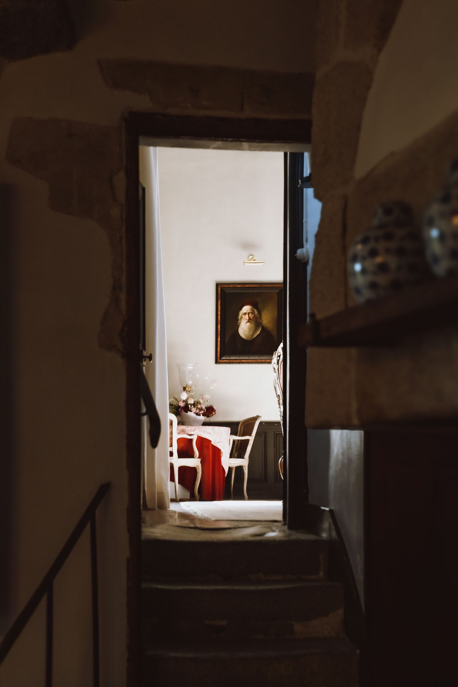 Dark hallway leading to a brightly lit room framed through a doorway.