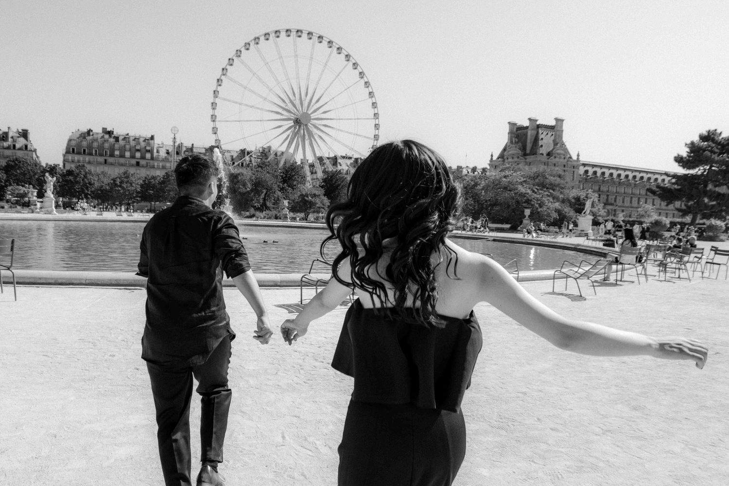 Editorial couple running through Jardin des Tuileries in Paris, playful black and white destination photography by Studio Reverie