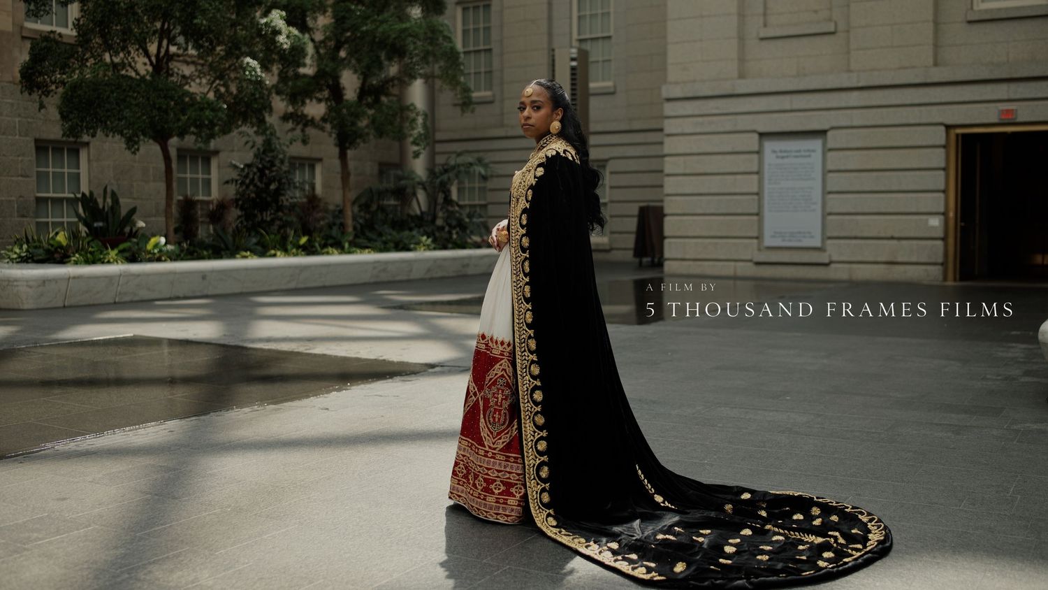 Woman in elegant black and red bridal lehenga with gold embroidery and long train, photographed by 5 Thousand Frames Films.
