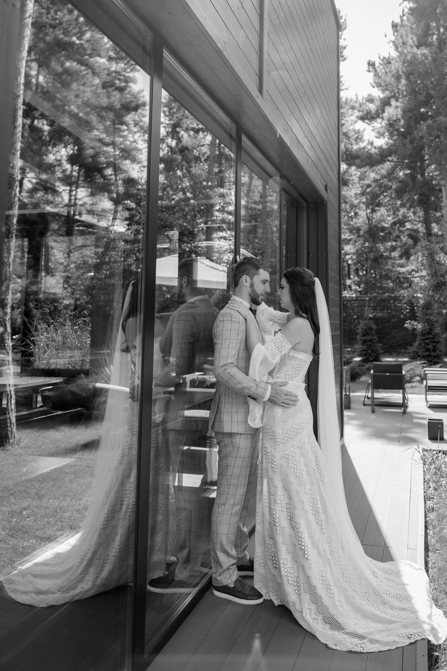 A series of romantic black and white wedding photos captured against glass windows.