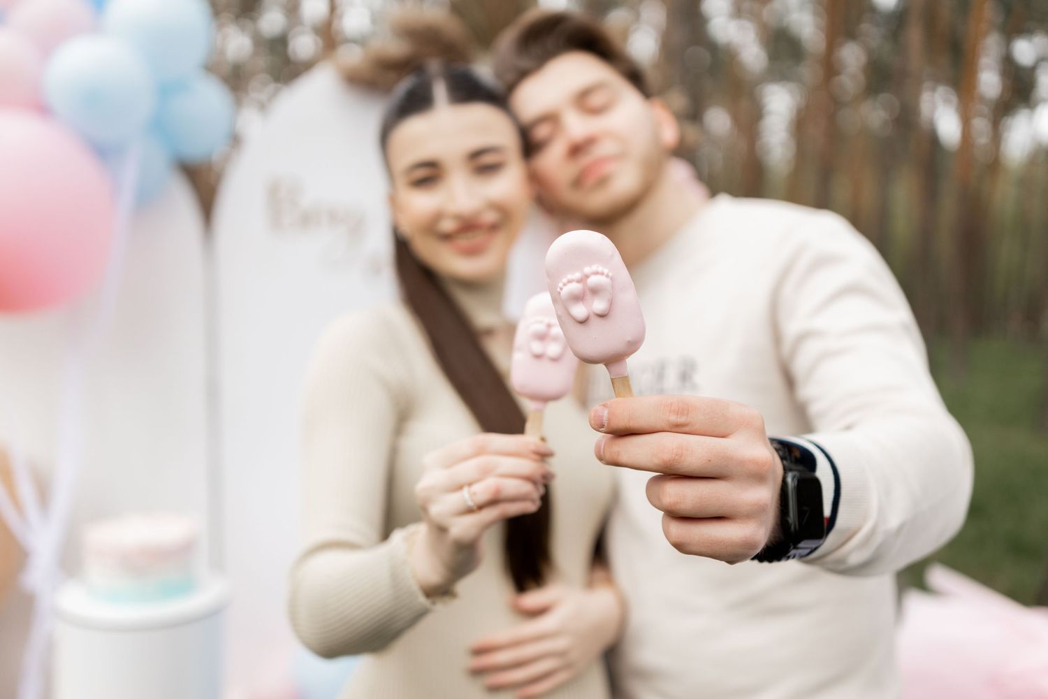Gender reveal celebration details with pastel balloons and decorative elements.