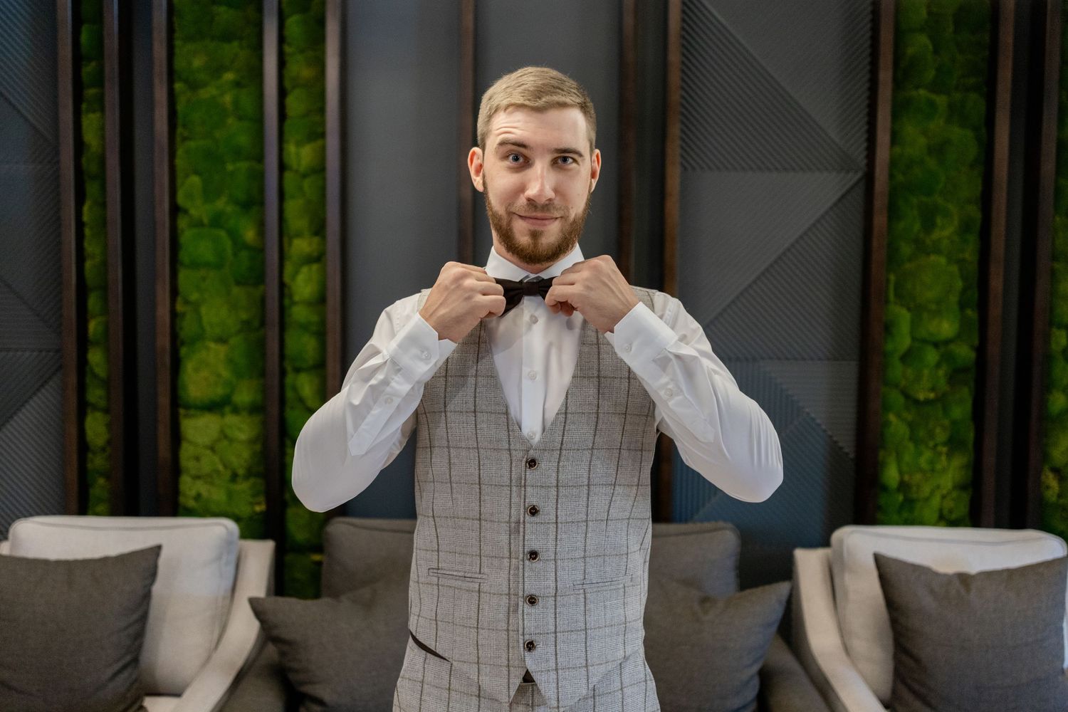 Stylish gray windowpane check suit vest paired with white dress shirt in modern interior setting.